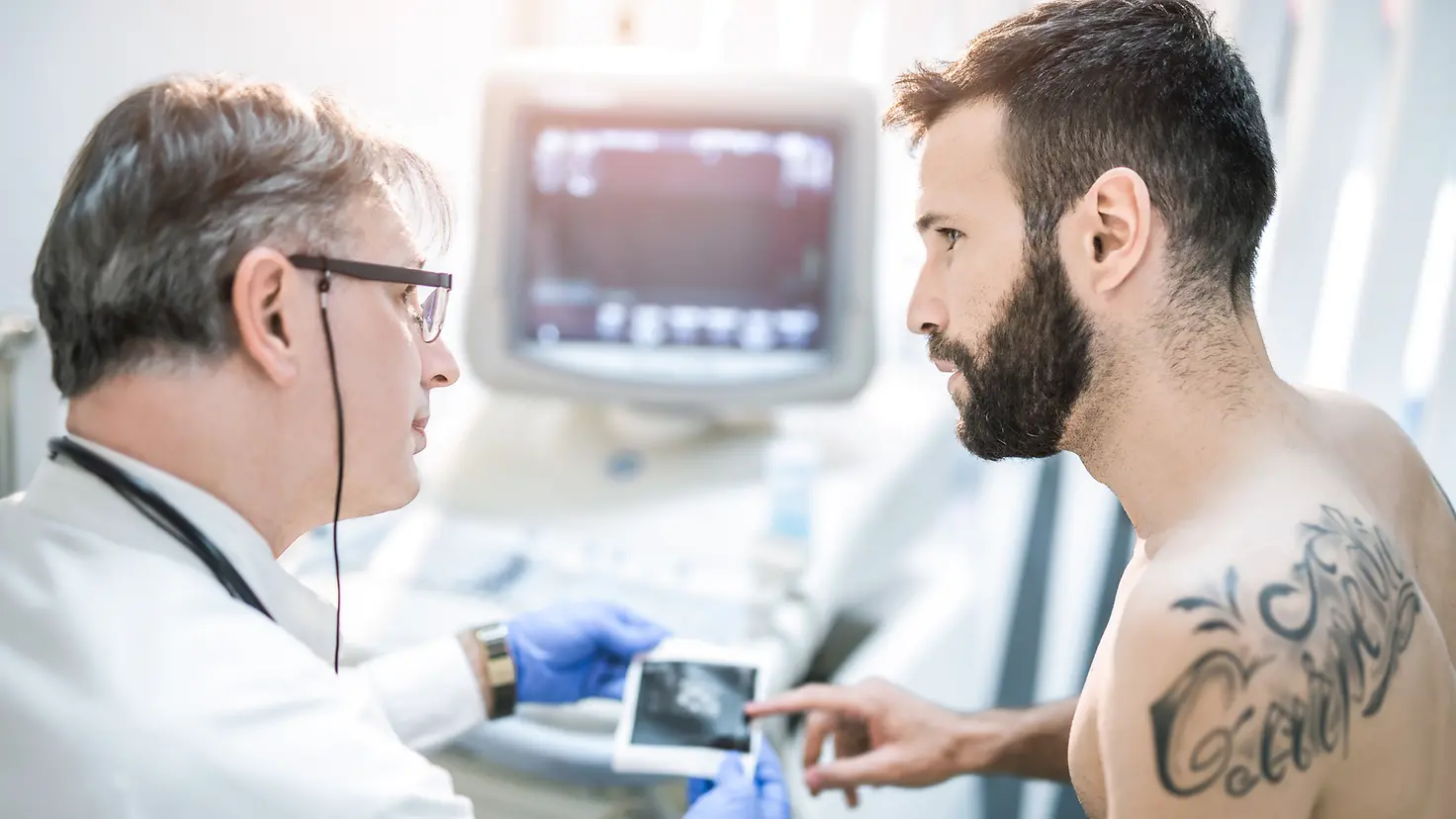 Ein Mann bespricht mit dem Arzt ein Ultraschallbild