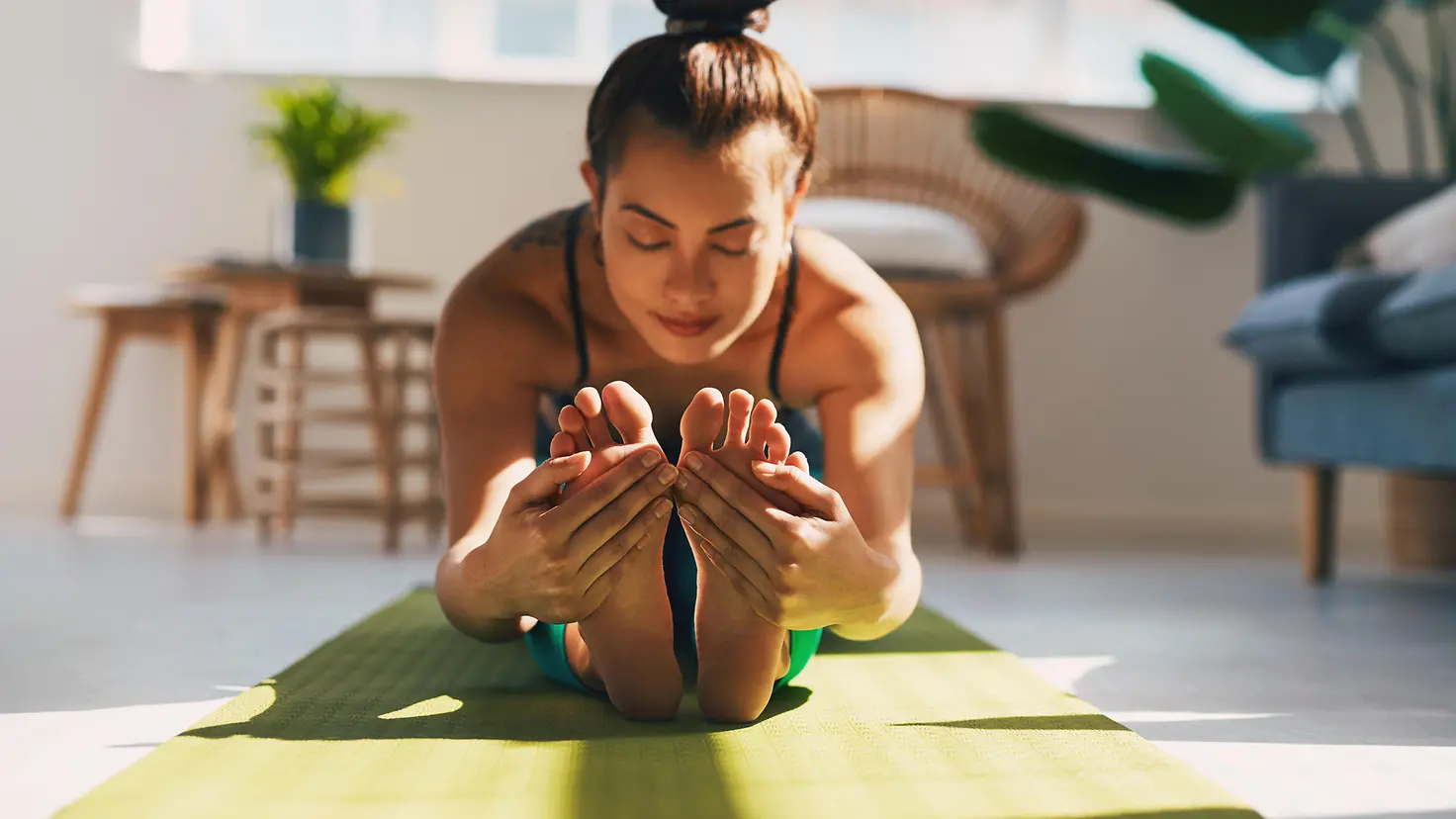 Eine Frau macht Yoga-Übungen mit einem Online-Kurs