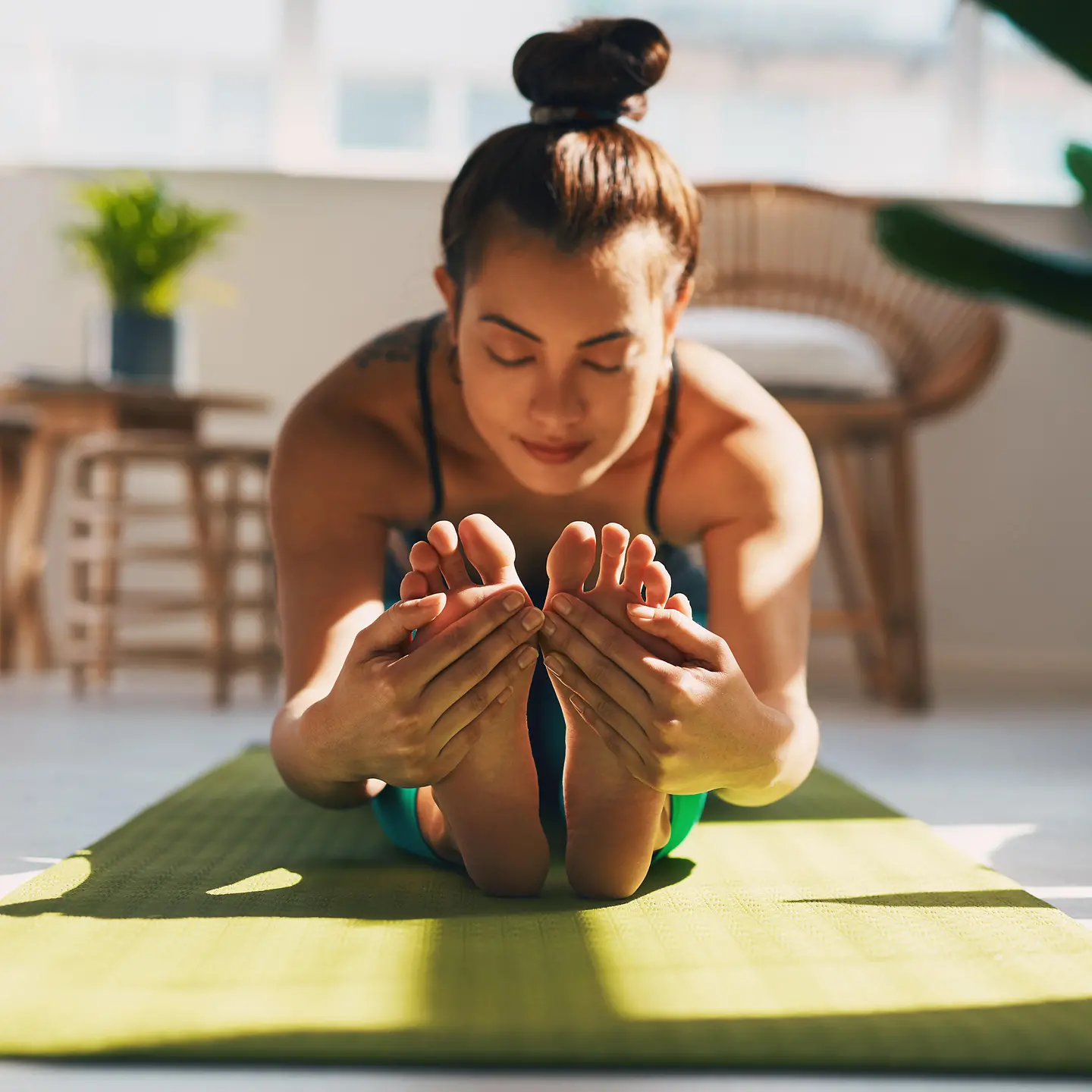 Eine Frau macht Yoga-Übungen mit einem Online-Kurs
