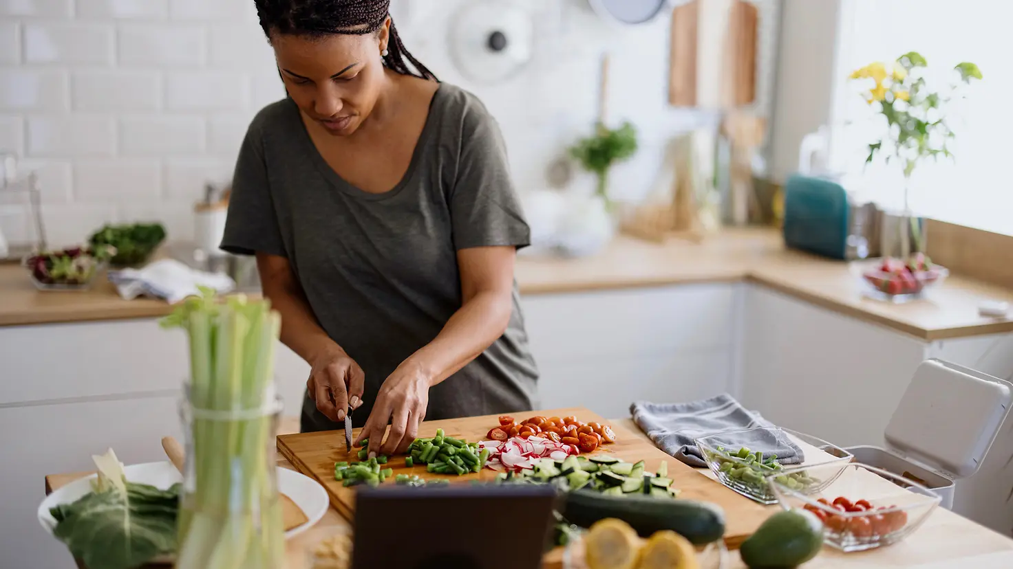 Eine Frau schneidet in ihrer Küche Gemüse klein