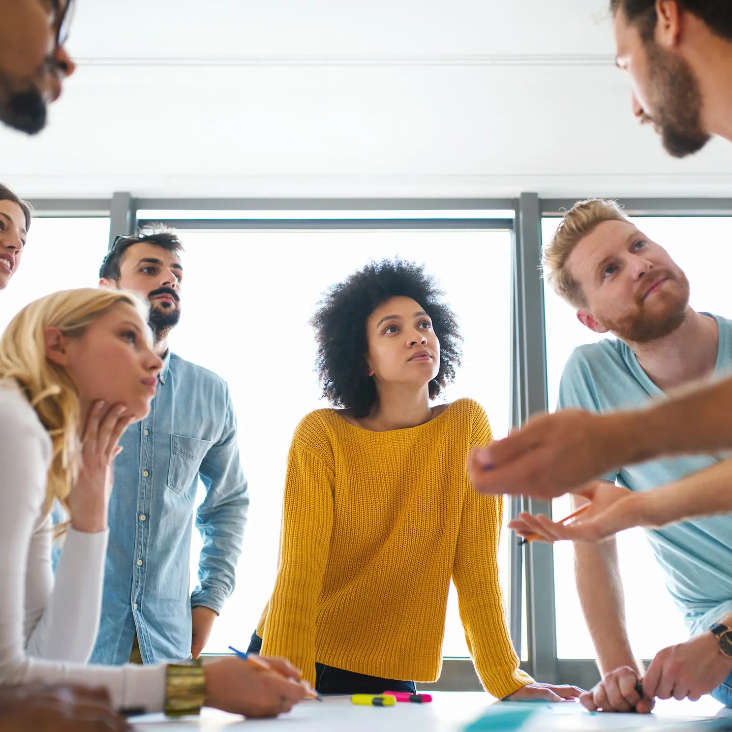 Ein junges Team diskutiert gemeinsam an einem Tisch