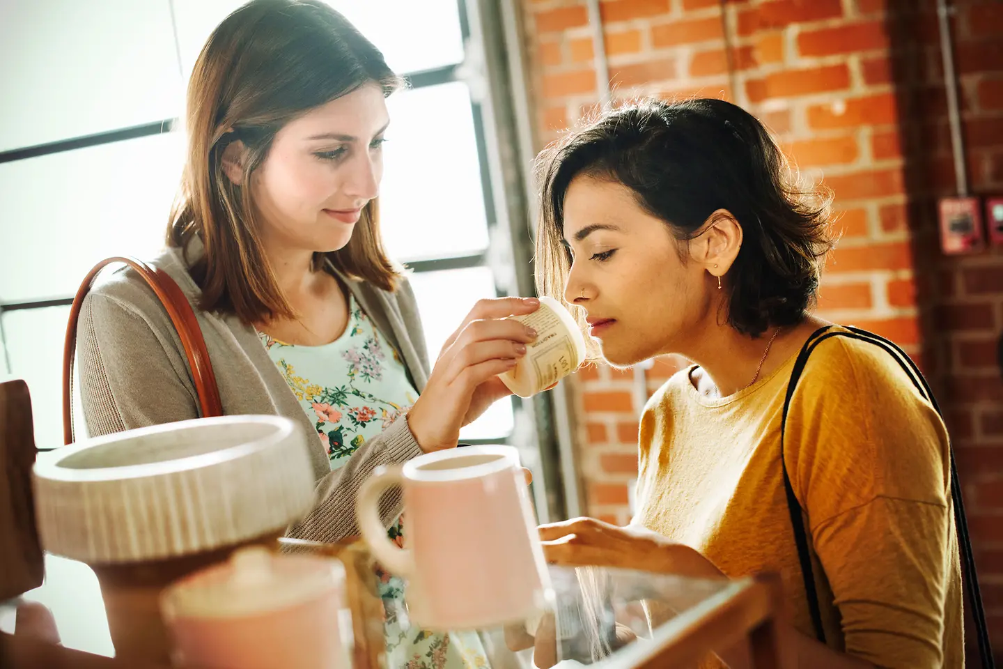 Eine junge Frau riecht an Kosmetikartikeln
