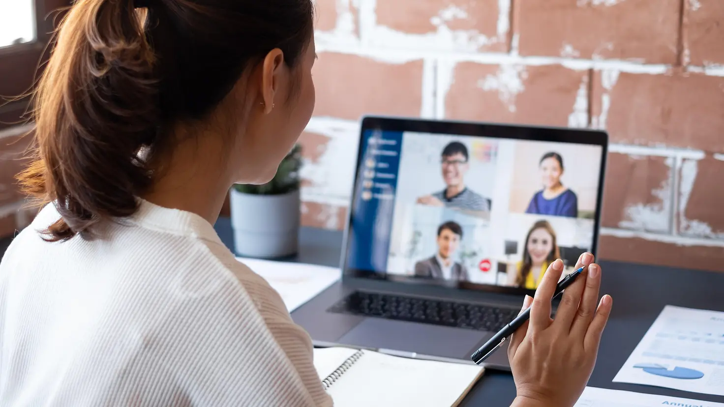 Das Bild zeigt eine Frau bei einer Videokonferenz an ihrem Laptop.