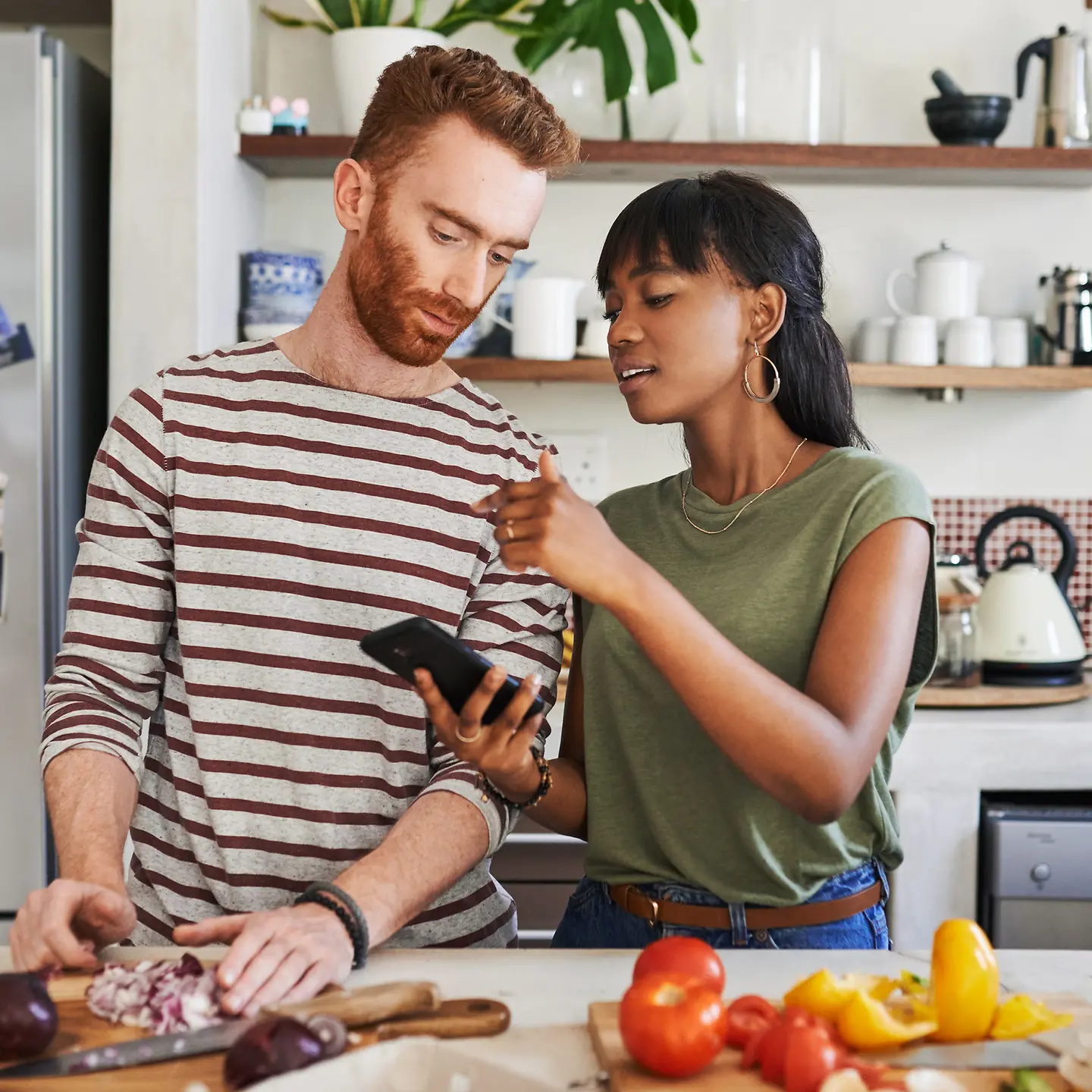 Junges Paar kocht gesund und vegan in seiner Küche