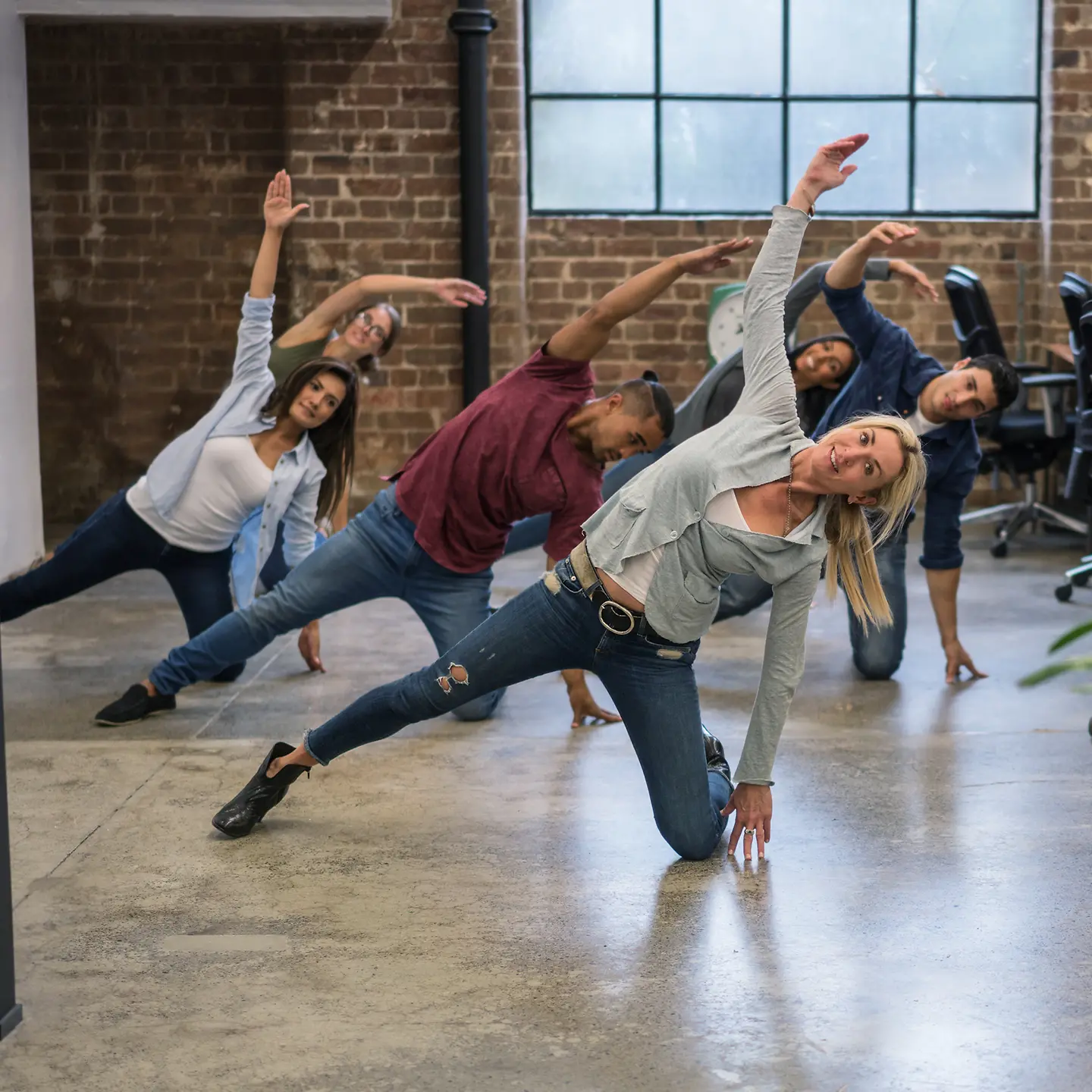 Eine Gruppe macht Sportübungen im Büro