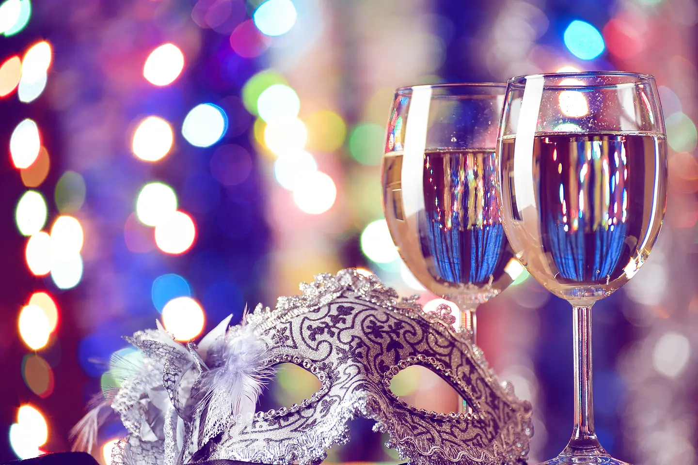 Eine Karnevalsmaske und zwei Sektgläser