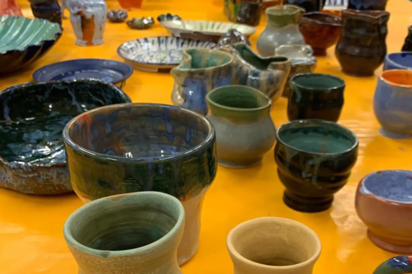 Auf einem Tisch stehen selbst getöpferte Vasen, Schalen und Krüge.