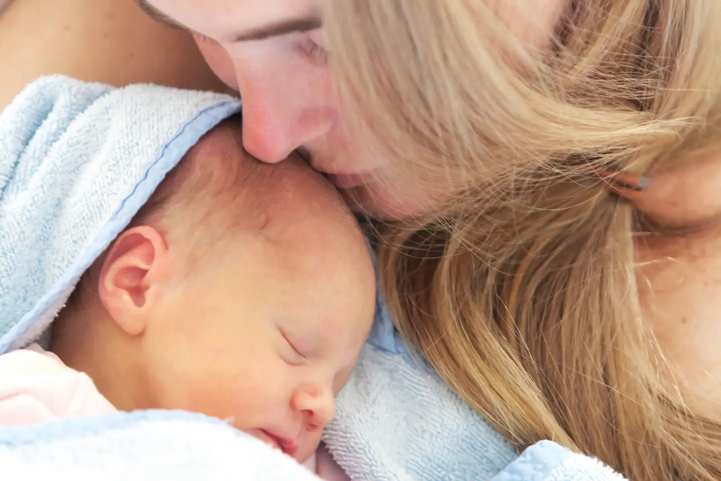 Junge Mutter hält ihr neugeborenes Kind in den Armen