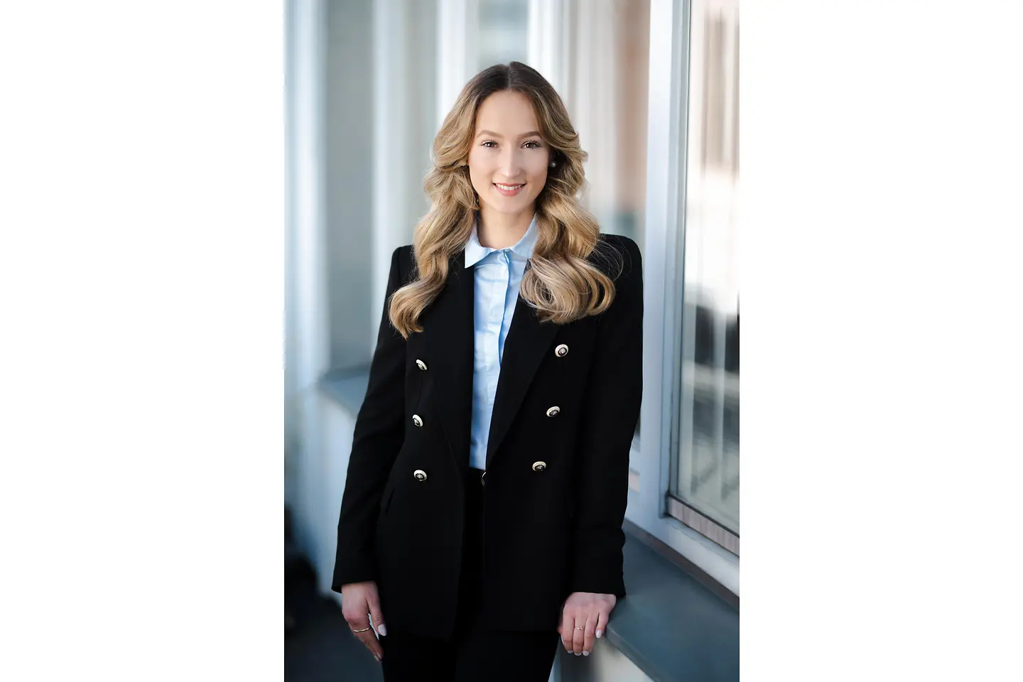 Eine junge Frau mit langen blonden Haaren lächelt in die Kamera