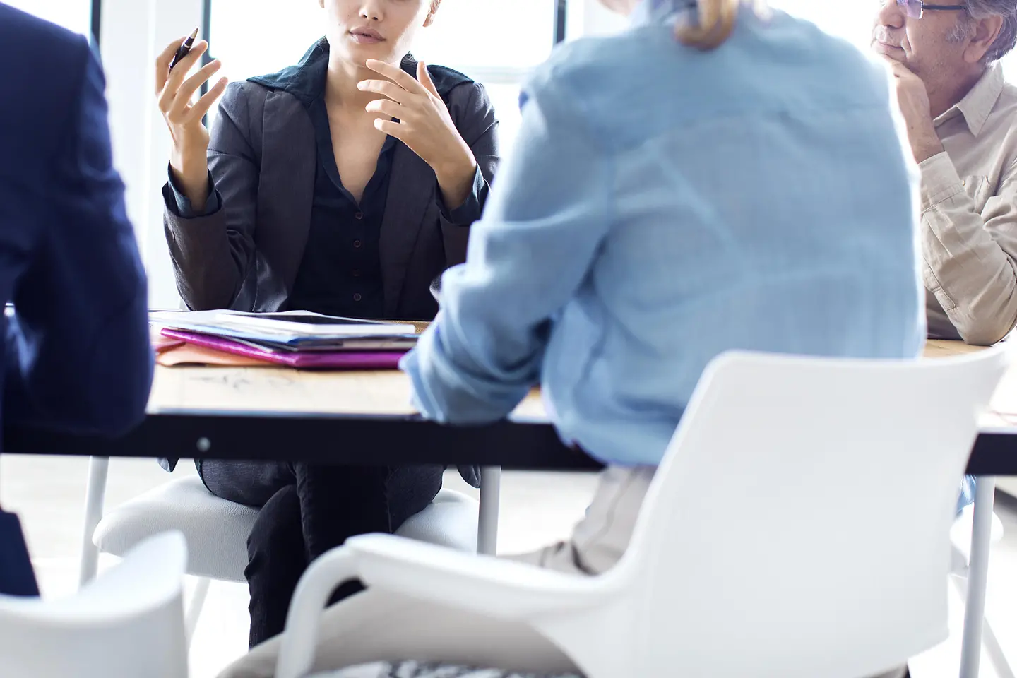 Zwei Frauen und zwei Männer sitzen an eine Tisch und haben ein Meeting.