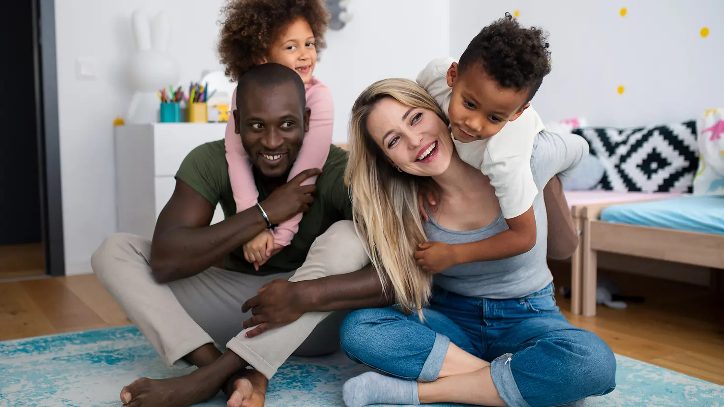 Happy multiracial family playing with airplanes toys at home
