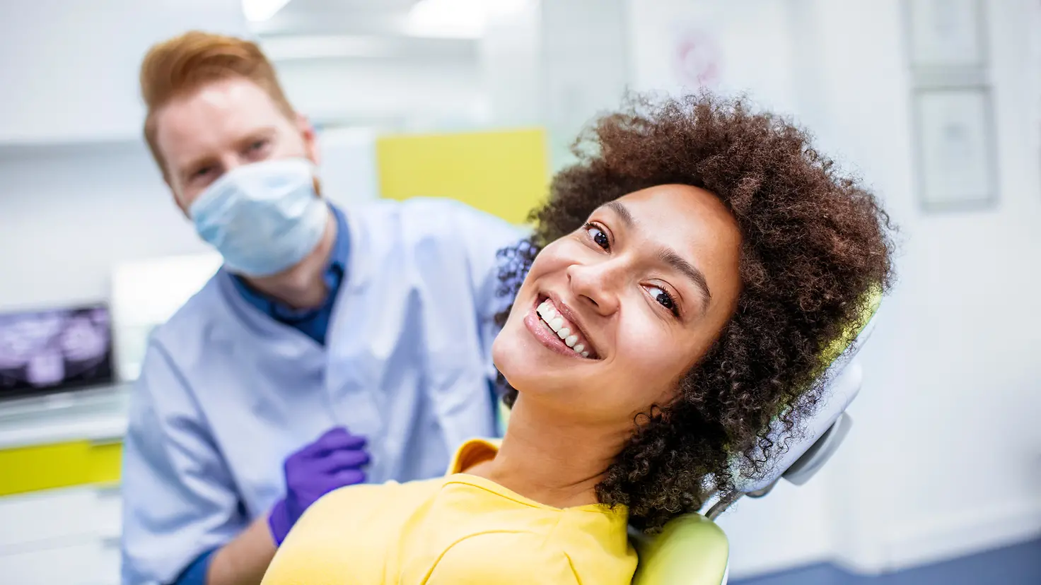 Ein Frau beim Zahnarzt zeigt ein Lächeln