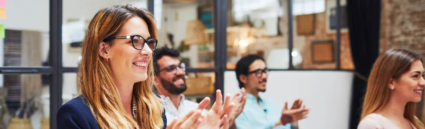 Young employees at the office clapping hands