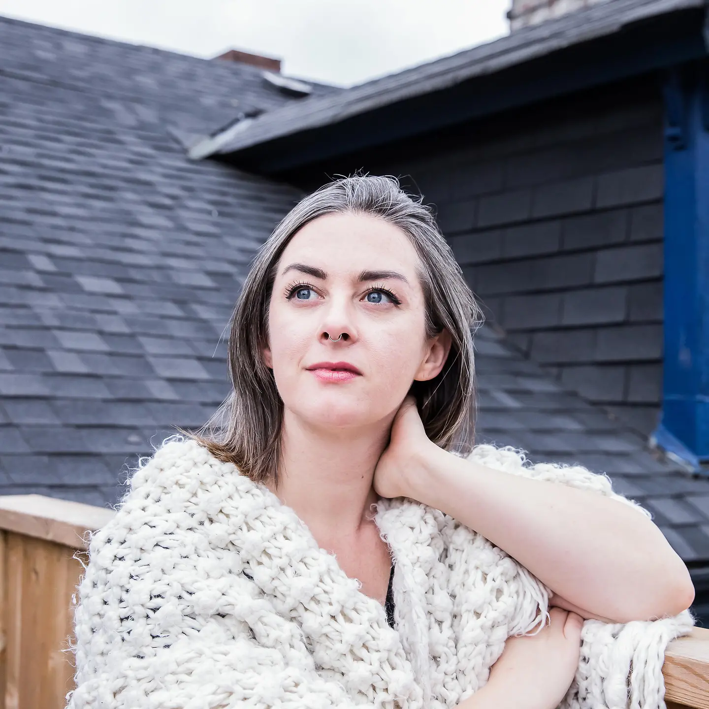 Junge Frau mit grauen Haaren auf einer Dachterrasse