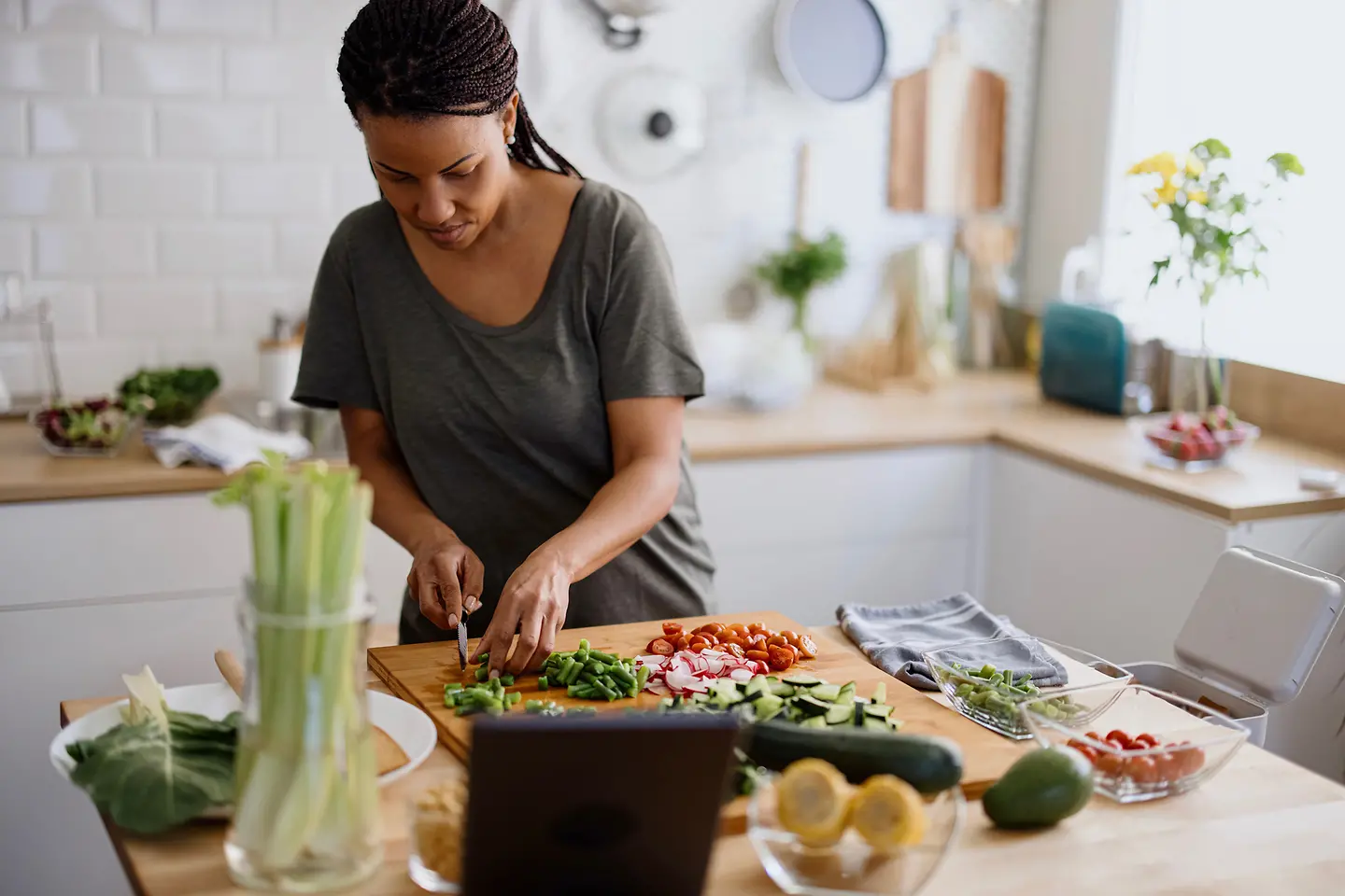 Eine Frau schneidet in ihrer Küche Gemüse klein