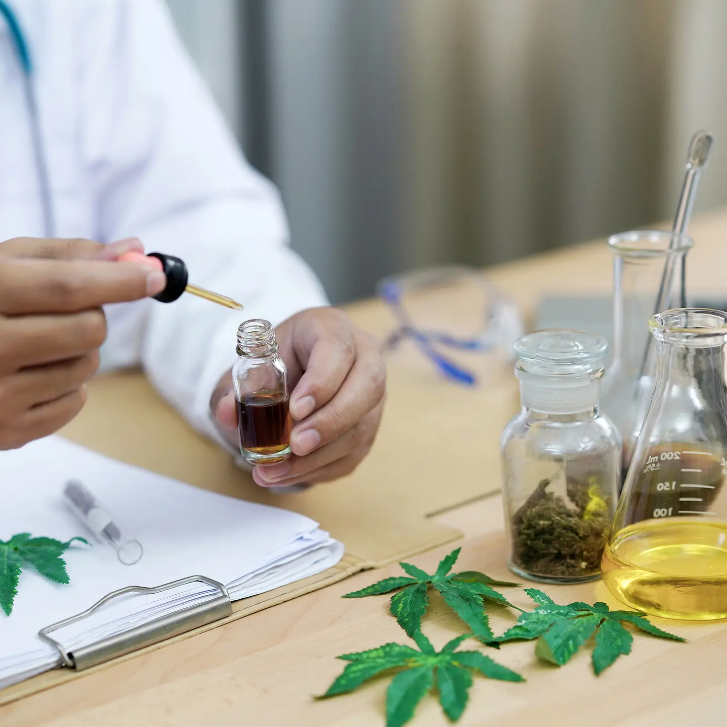 Ein Wissenschaftler tropft Cannabis-Öl aus einer Pipette 