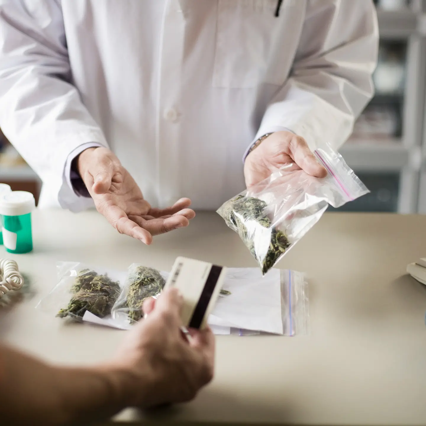 Ein Apotheker gibt einem Kunde medizinisches Cannabis auf Rezept