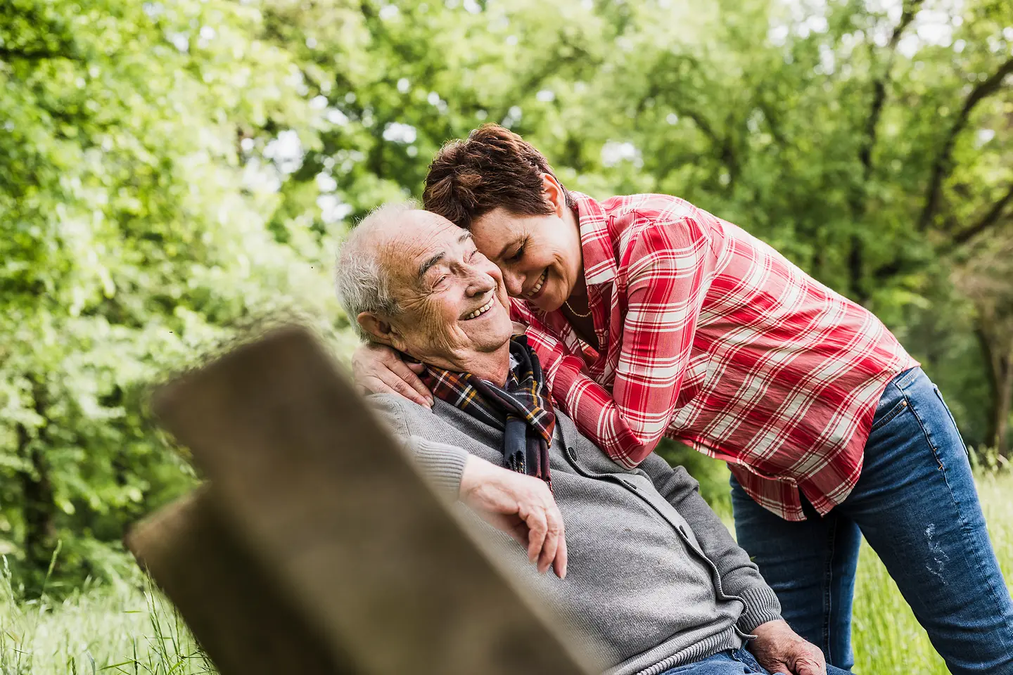 Eine junge Frau umarmt einen älteren Herrn