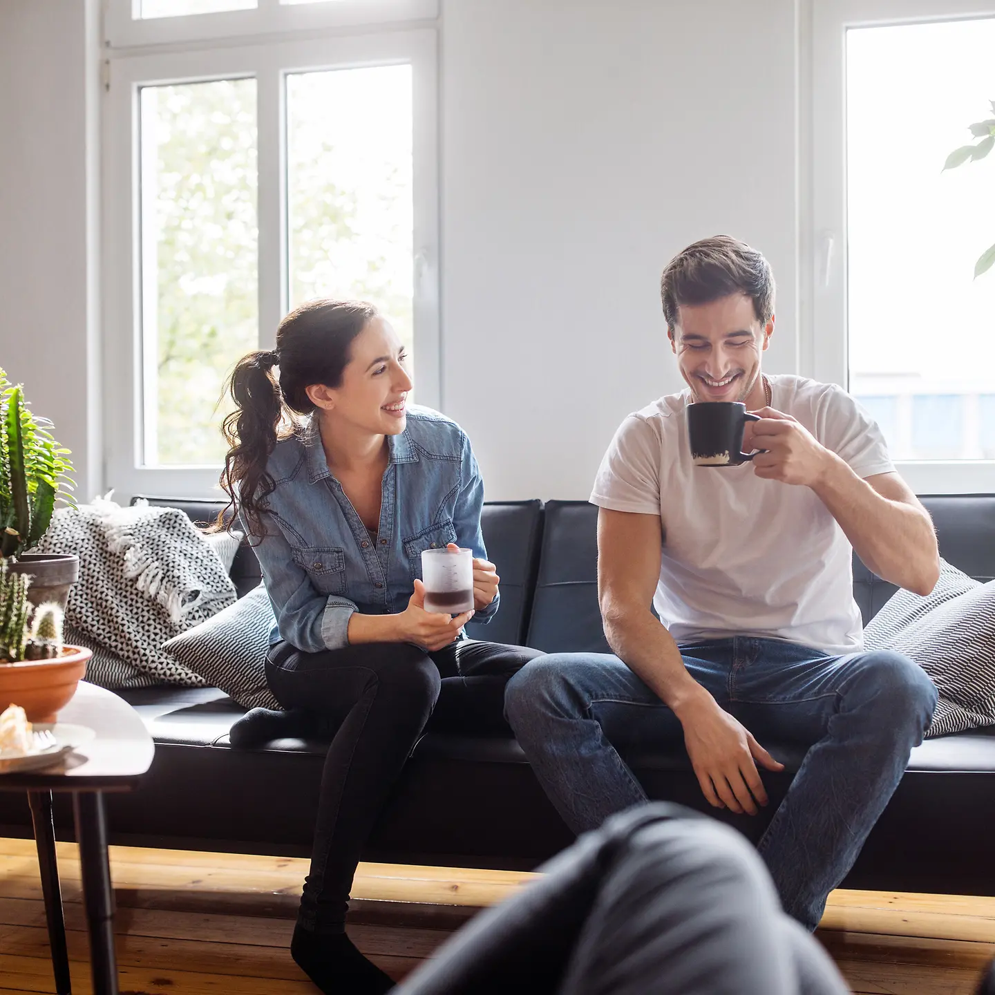 Zwei junge Studenten sitzen gemeinsam auf der Couch und entspannen. 