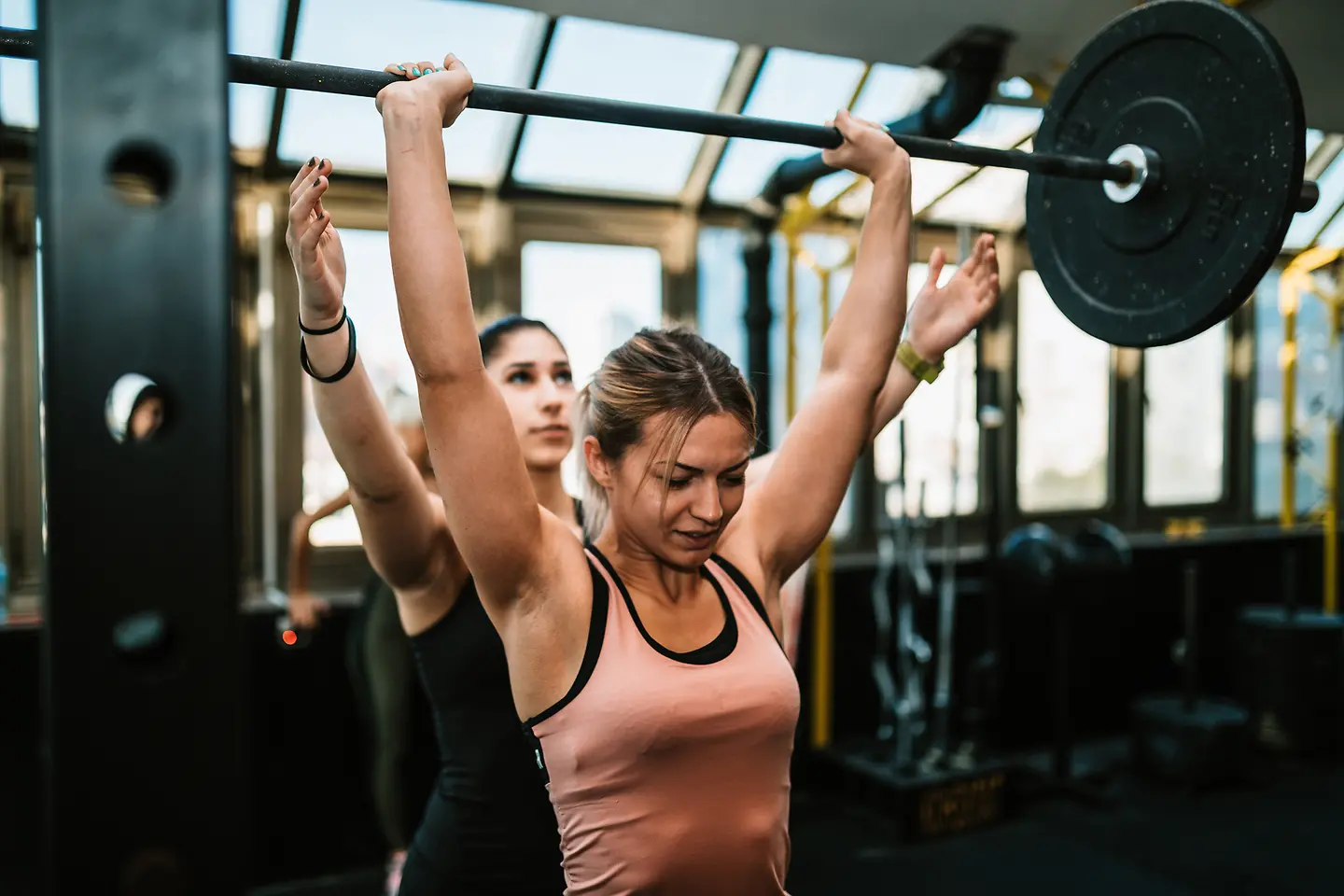 Eine junge Frau macht Hanteltraining und trainiert ihre Muskeln.
