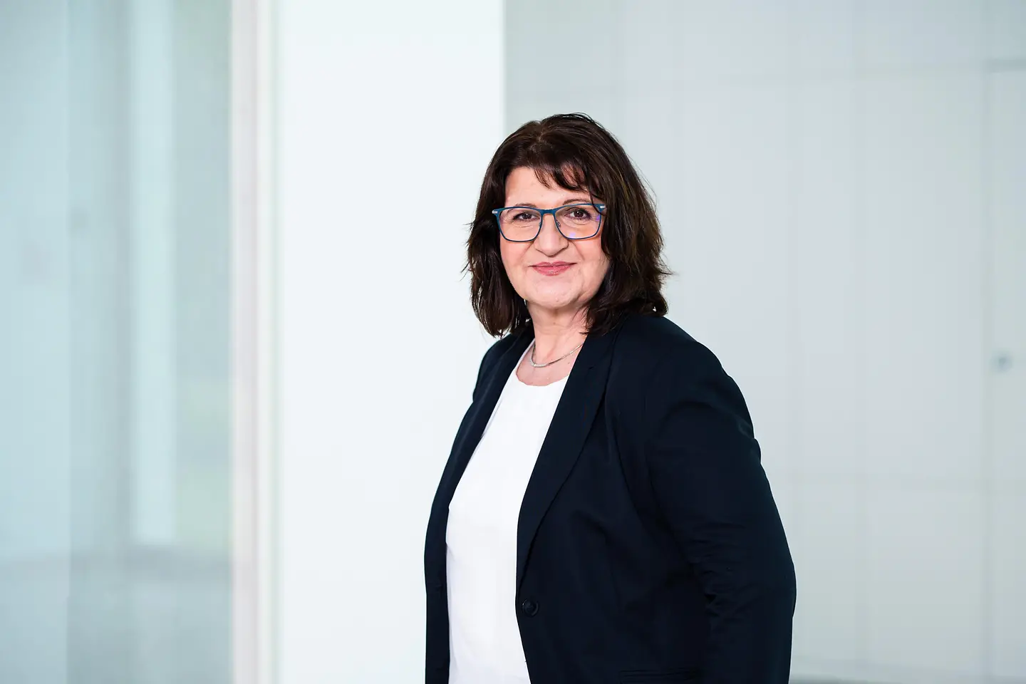 Bettina Altesleben vor einer weißen Wand.