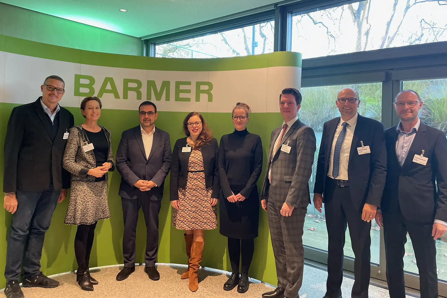 Die Teilnehmenden der BARMER Gesundheitskonferenz am Bondensee. Fünf Männer und drei Frauen stehen vor einer Wand mit dem Schriftzug BARMER.