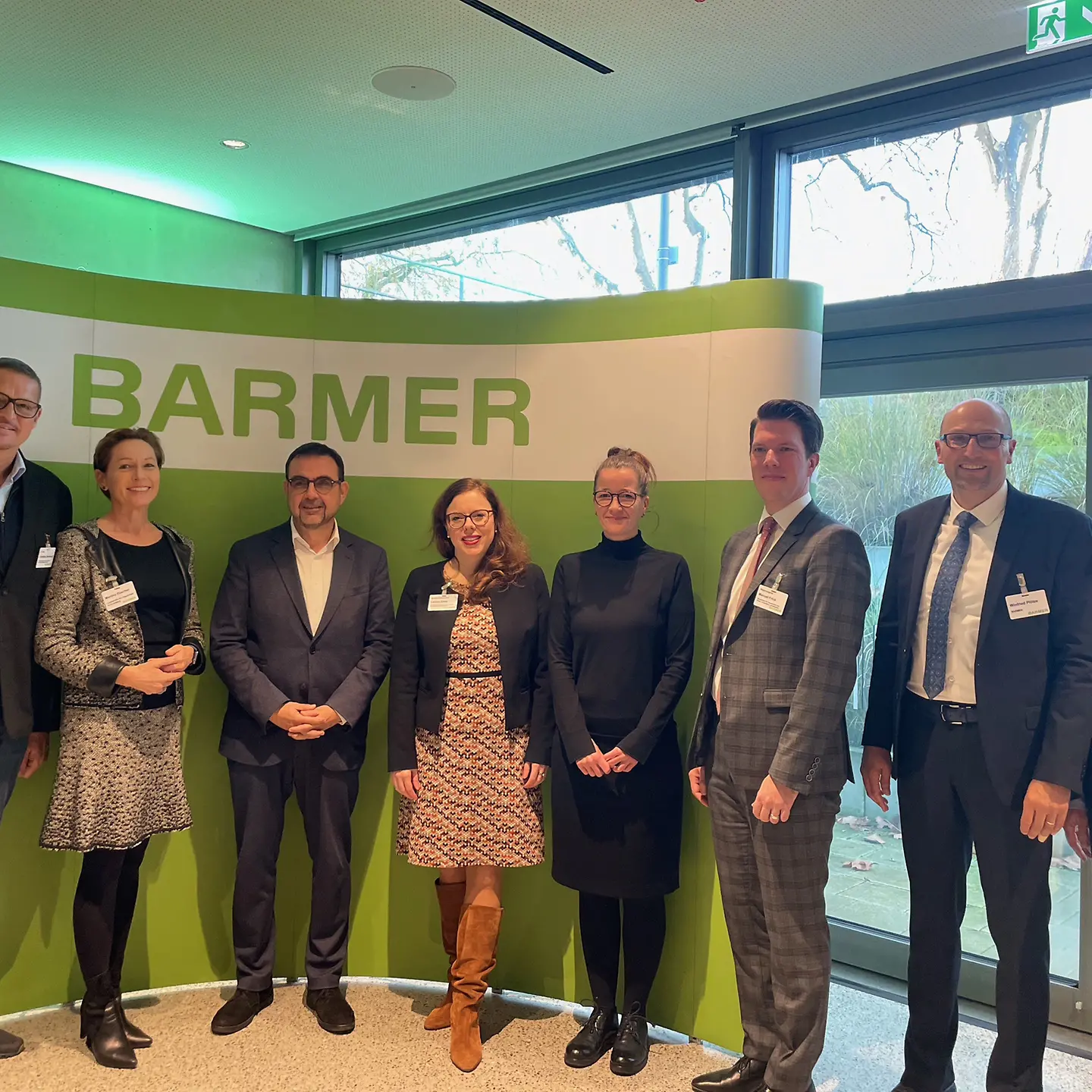 Die Teilnehmenden der BARMER Gesundheitskonferenz am Bondensee. Fünf Männer und drei Frauen stehen vor einer Wand mit dem Schriftzug BARMER.