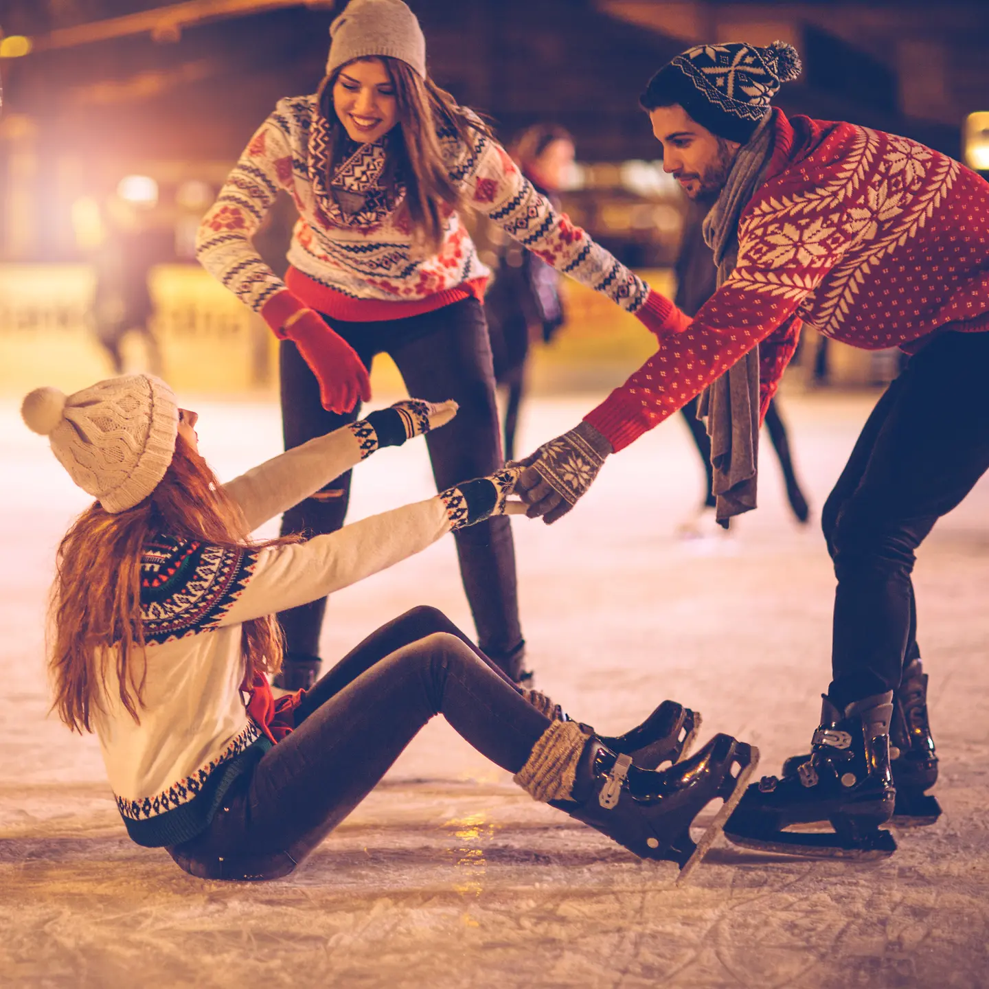 Freunde halten sich an Weihnachten fit und haben Spaß beim Eislaufen