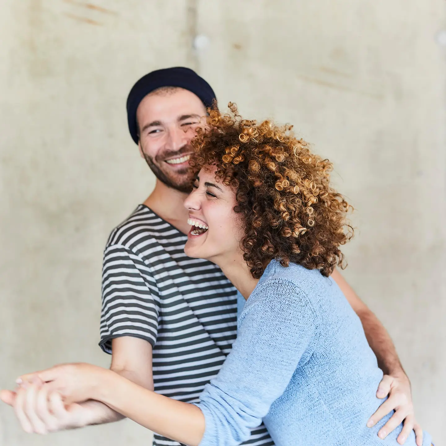Ein junges Paar umarmt sich und lacht