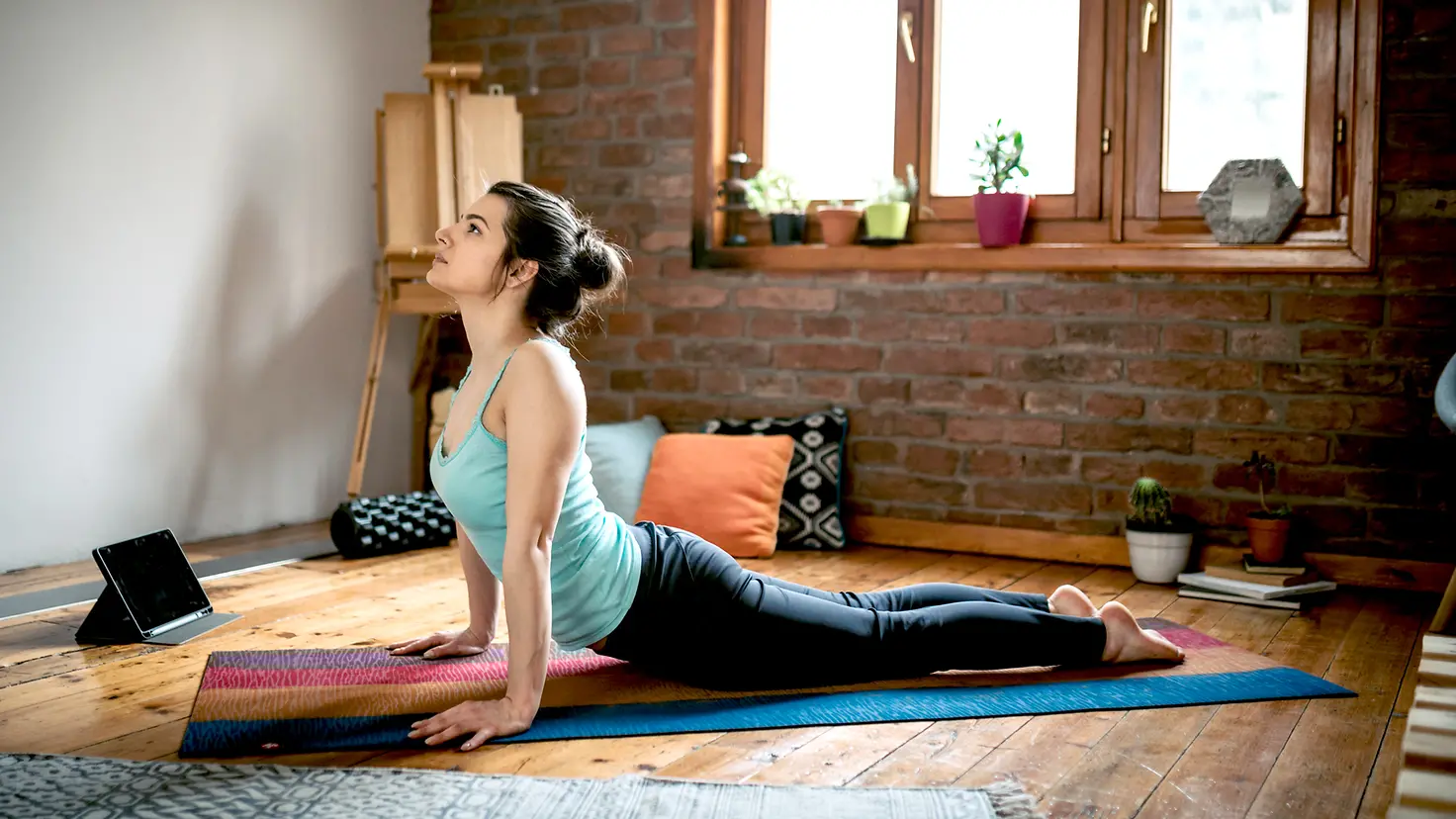 Eine Frau führt die Yoga-Stellung Kobra für mehr Beweglichkeit in der Wirbelsäule aus