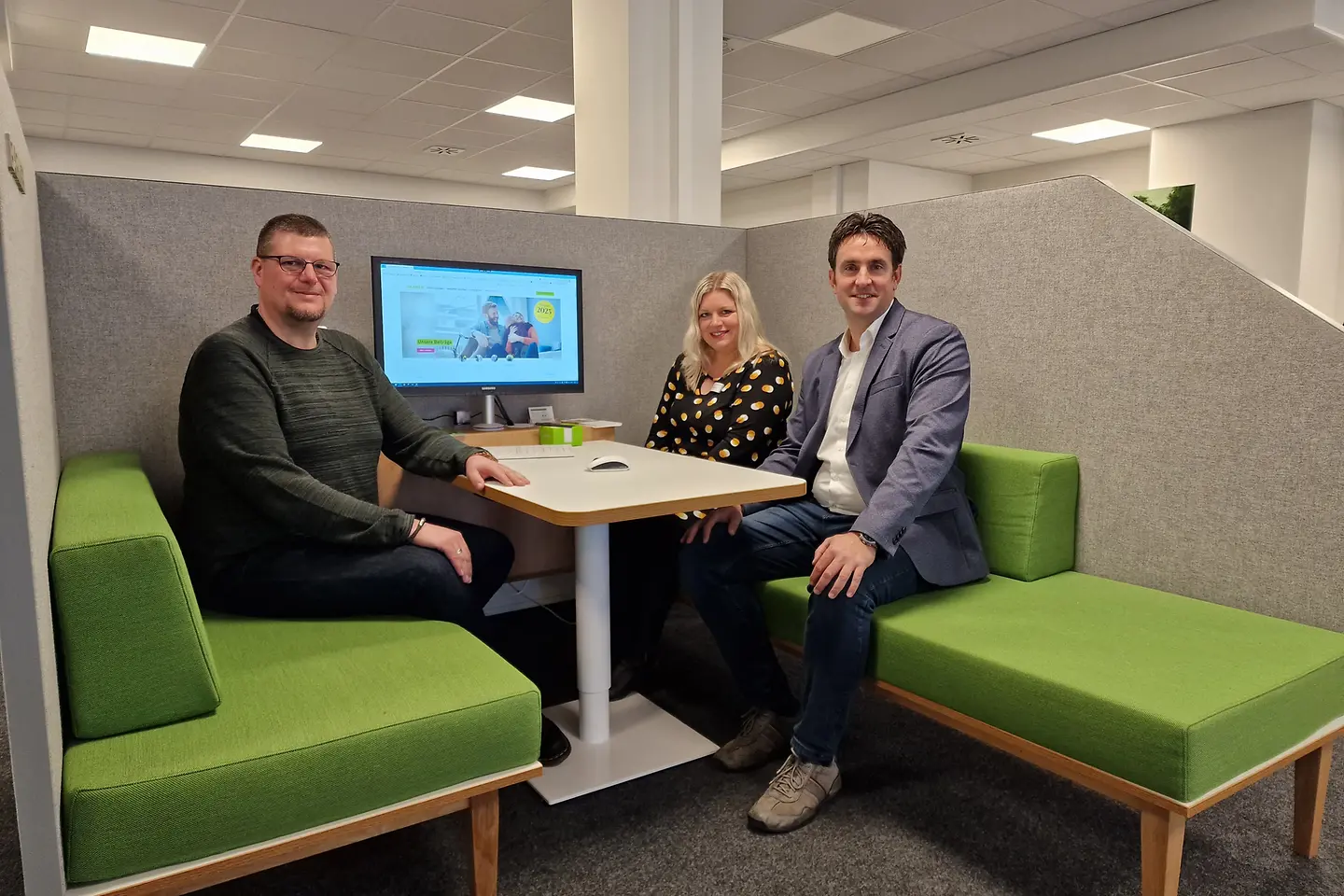 Drei Mitarbeiter der BARMER sitzen in einer Beratungsbox.