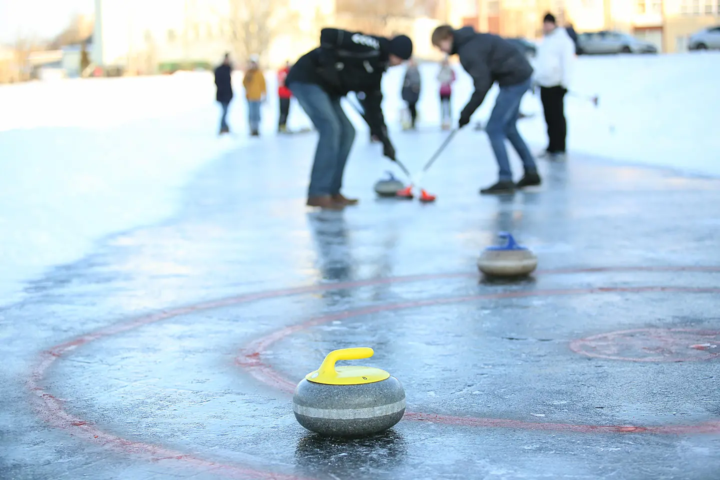 Zu sehen sind Männer auf einer Eisfläche beim Eisstockschießen