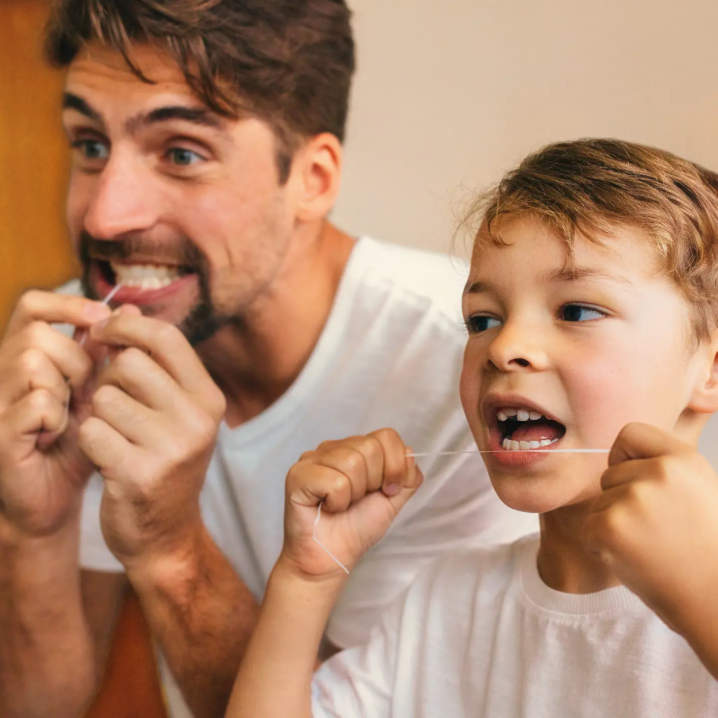 Ein Vater und sein Sohn pflegen zusammen ihre Zähne und nehmen am Bonusprogramm der Barmer teil.