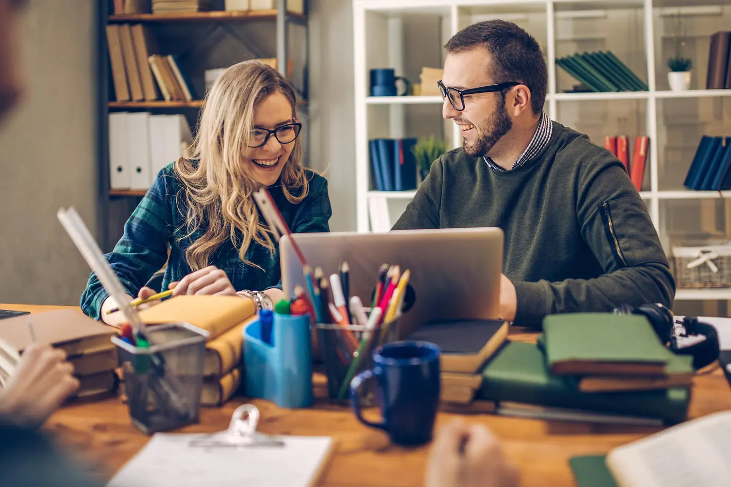 Eine Frau und ein Mann arbeiten zusammen an einem Laptop