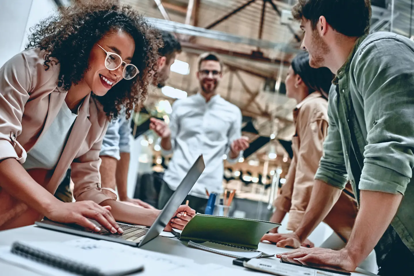Zu sehen sind Glückliche Teammitglieder am Schreibtisch
