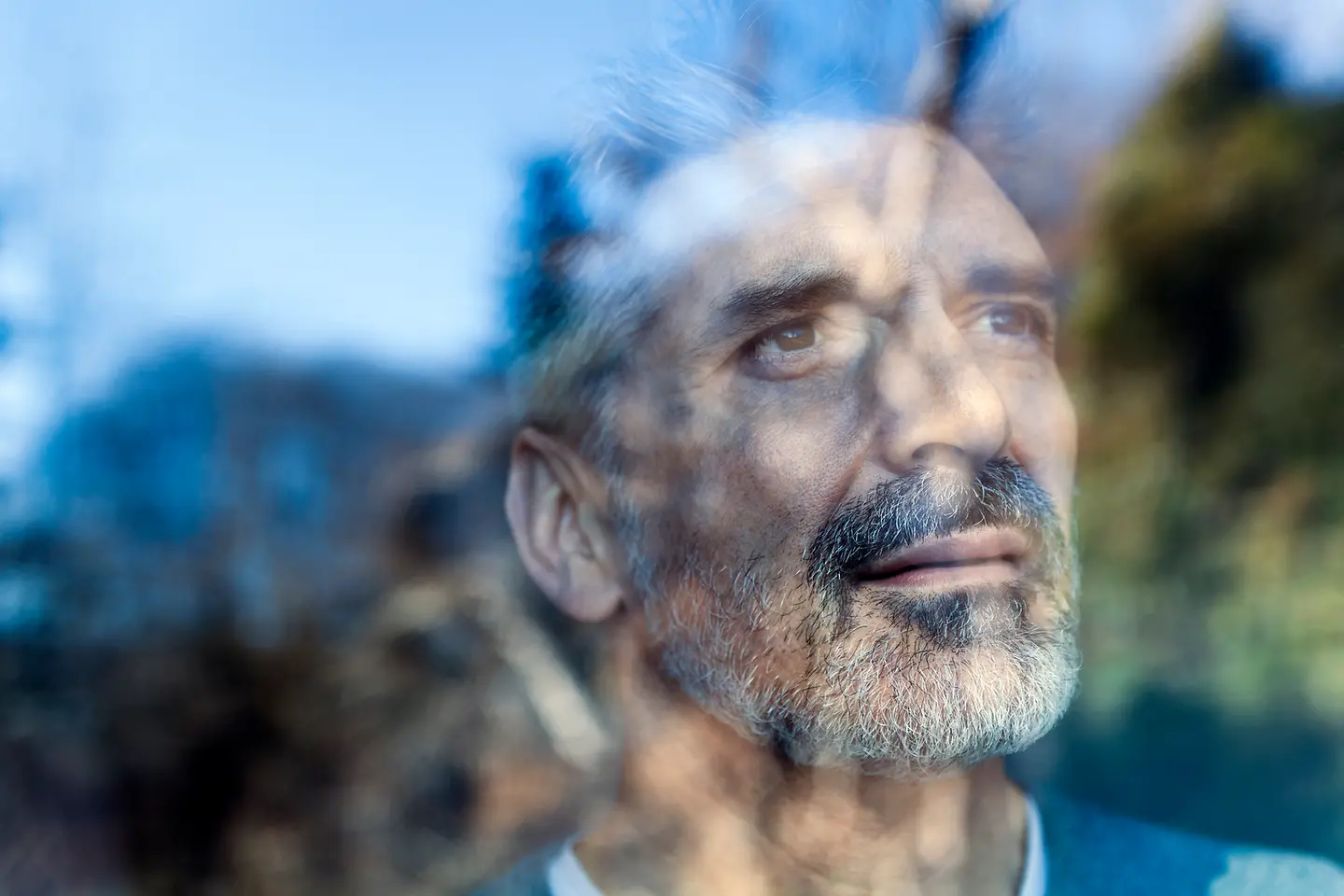 Ein einsamer Mann schaut nachdenklich aus dem Fenster