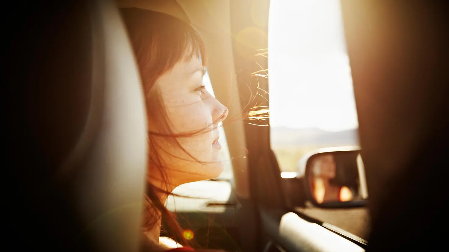 Eine Frau schaut während einer Autofahrt aus dem Fenster
