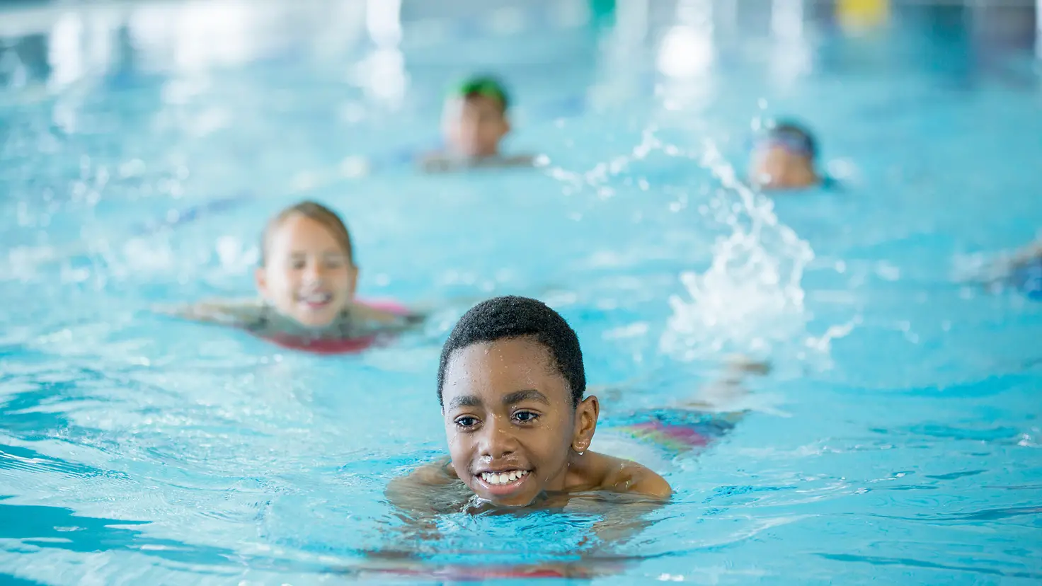 Kinder schwimmen Bahnen um ein Schwimmabzeichen zu erhalten