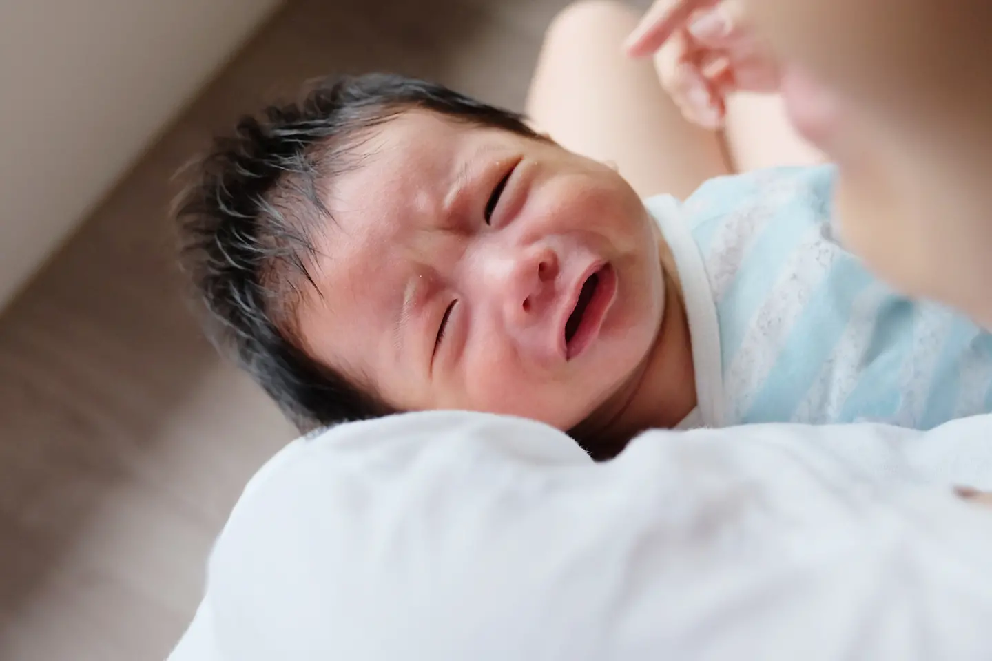 Ein weinendes Baby auf dem Arm einer Frau.