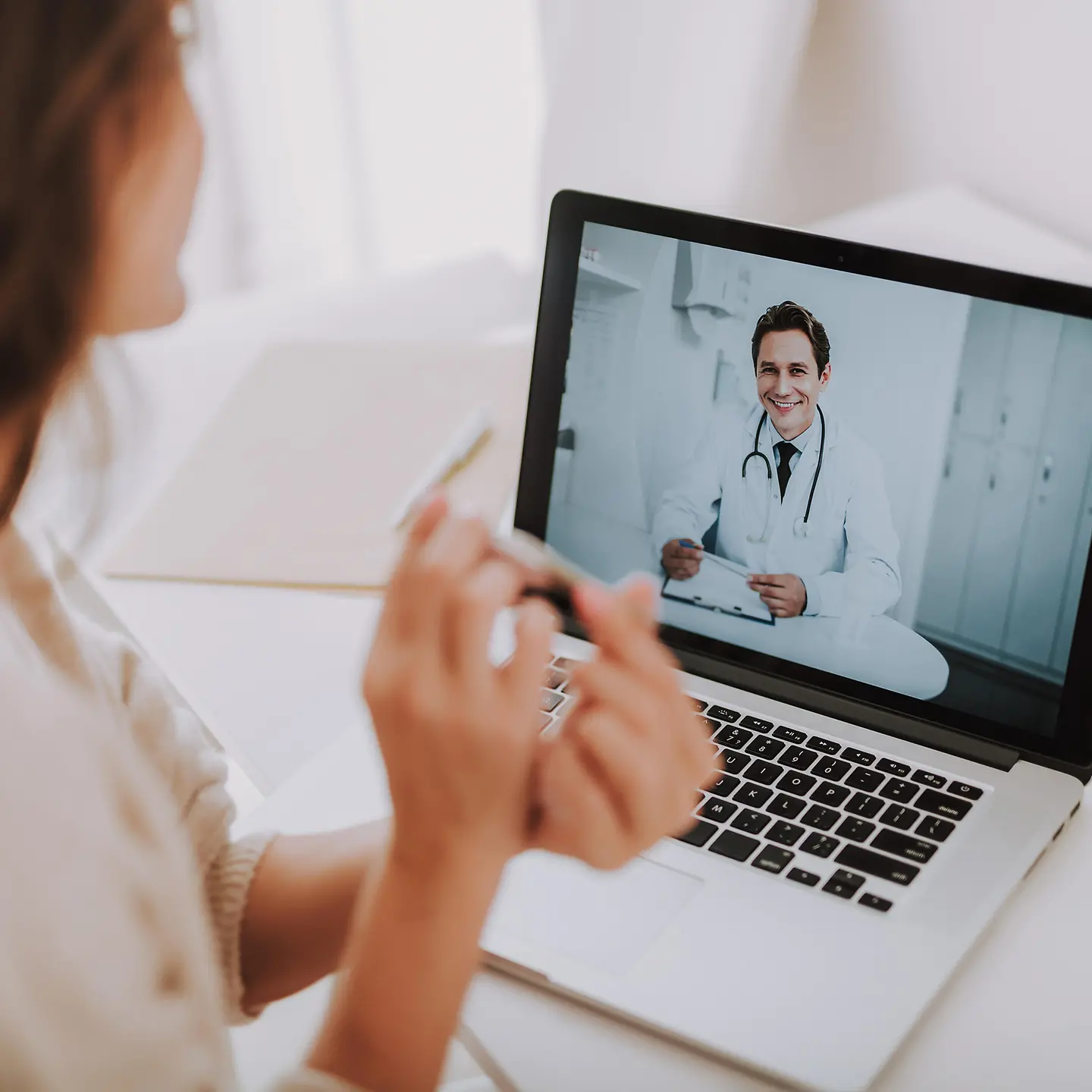 Zu sehen ist eine Patientin an einem Tablet mit einem Teledoktor auf dem Bildschirm