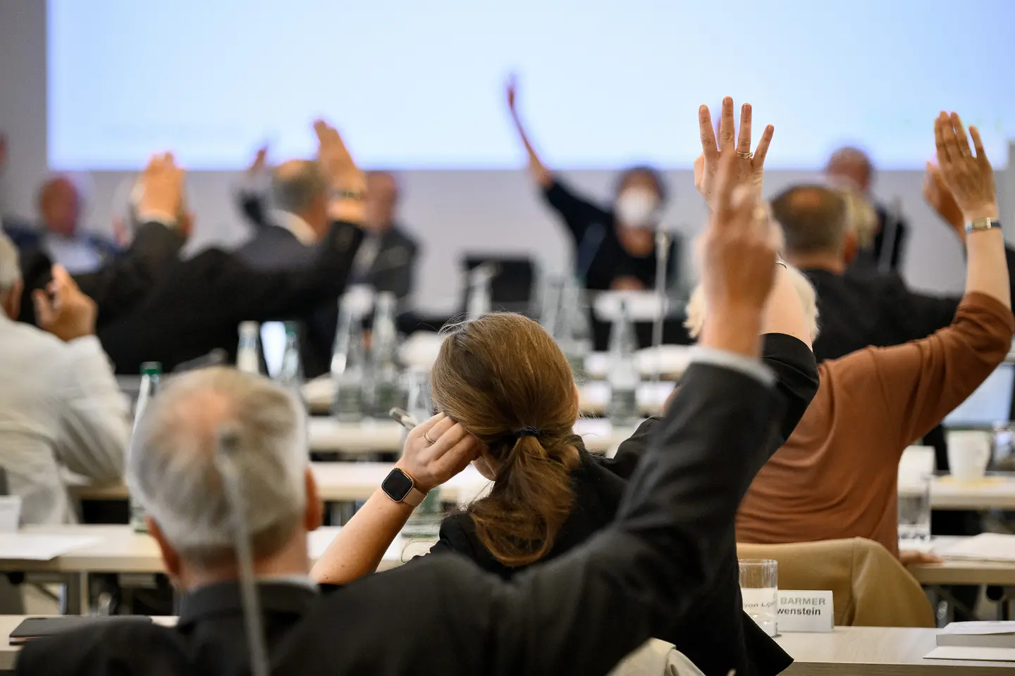 Bei einer Abstimmung des BARMER-Verwaltungsrates heben verschiedene Verwaltungsratsmitglieder ihre Hand