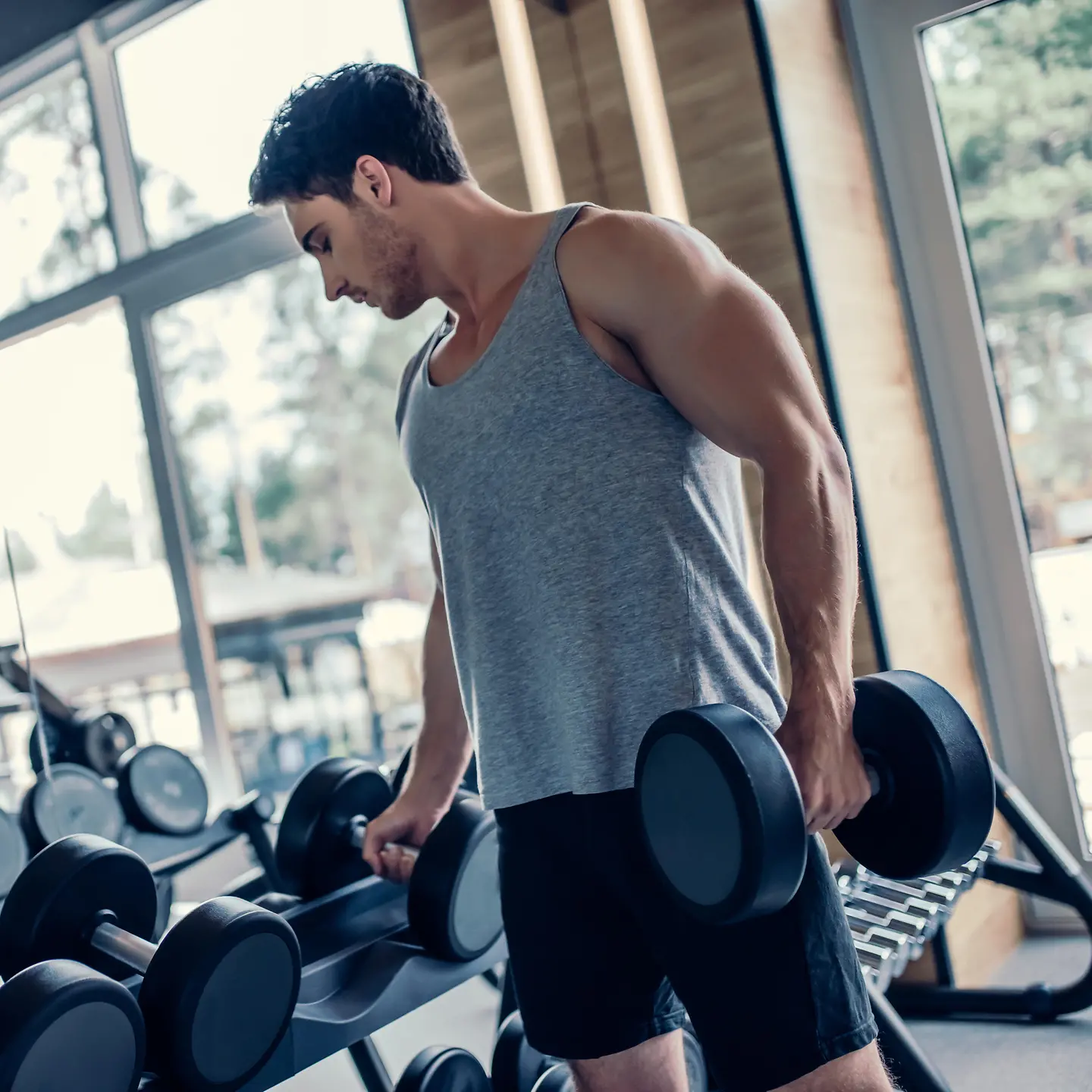 Zu sehen ist ein Mann mit Hanteln