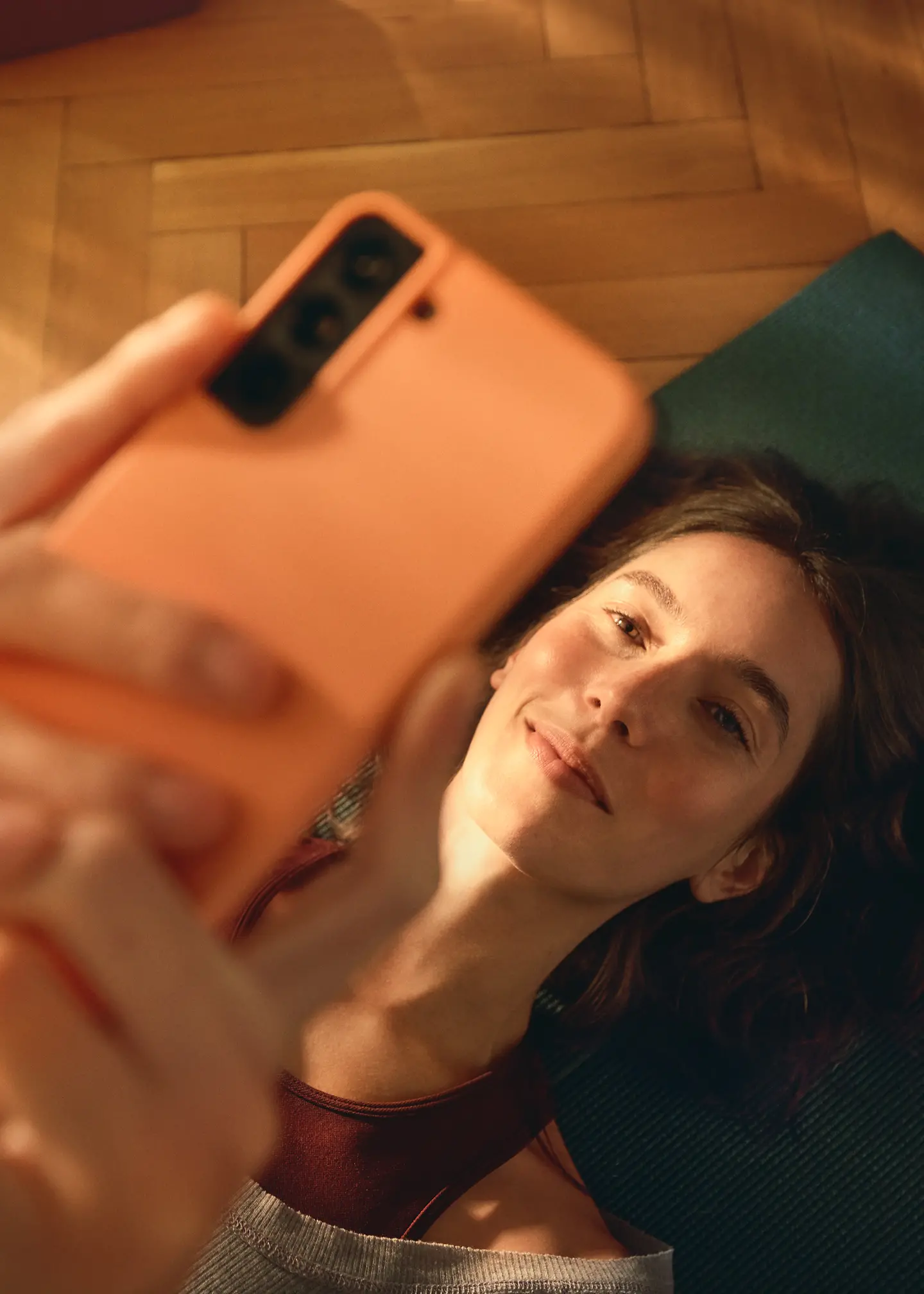 Eine Frau mit braunen schulterlangen Haaren schaut auf ihr Smartphone.
