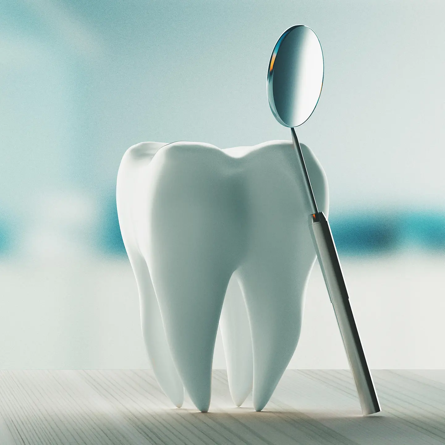 Zu sehen ist ein künstlicher Zahn, an dem ein Mundspiegel angelehnt ist.