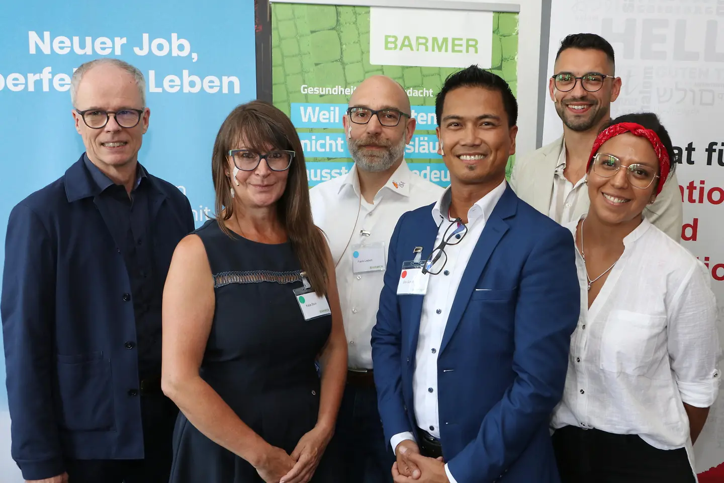 Die Podiumsteilnehmer stehen vor einer Wand.