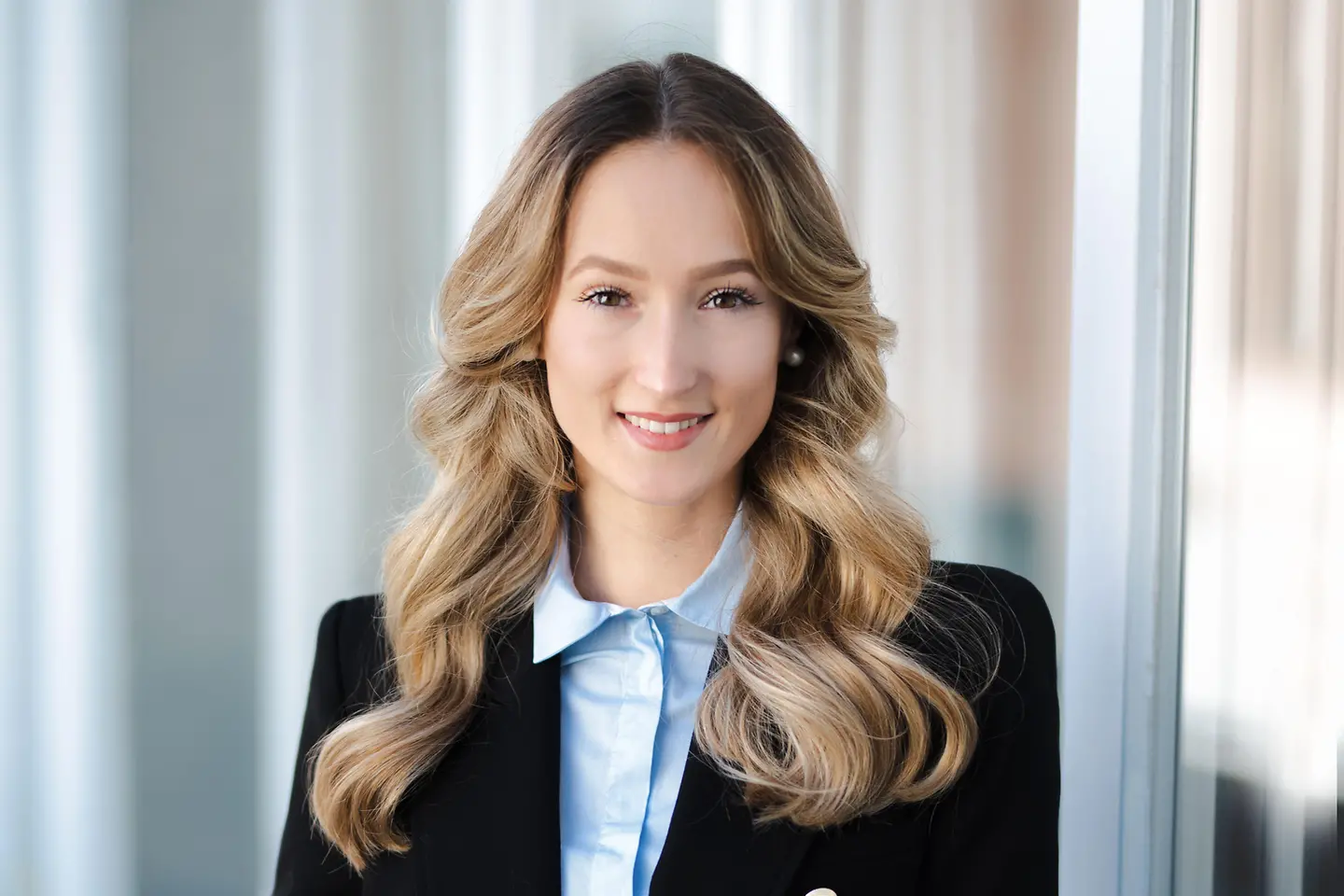 Eine junge Frau mit langen Haaren lächelt in die Kamera