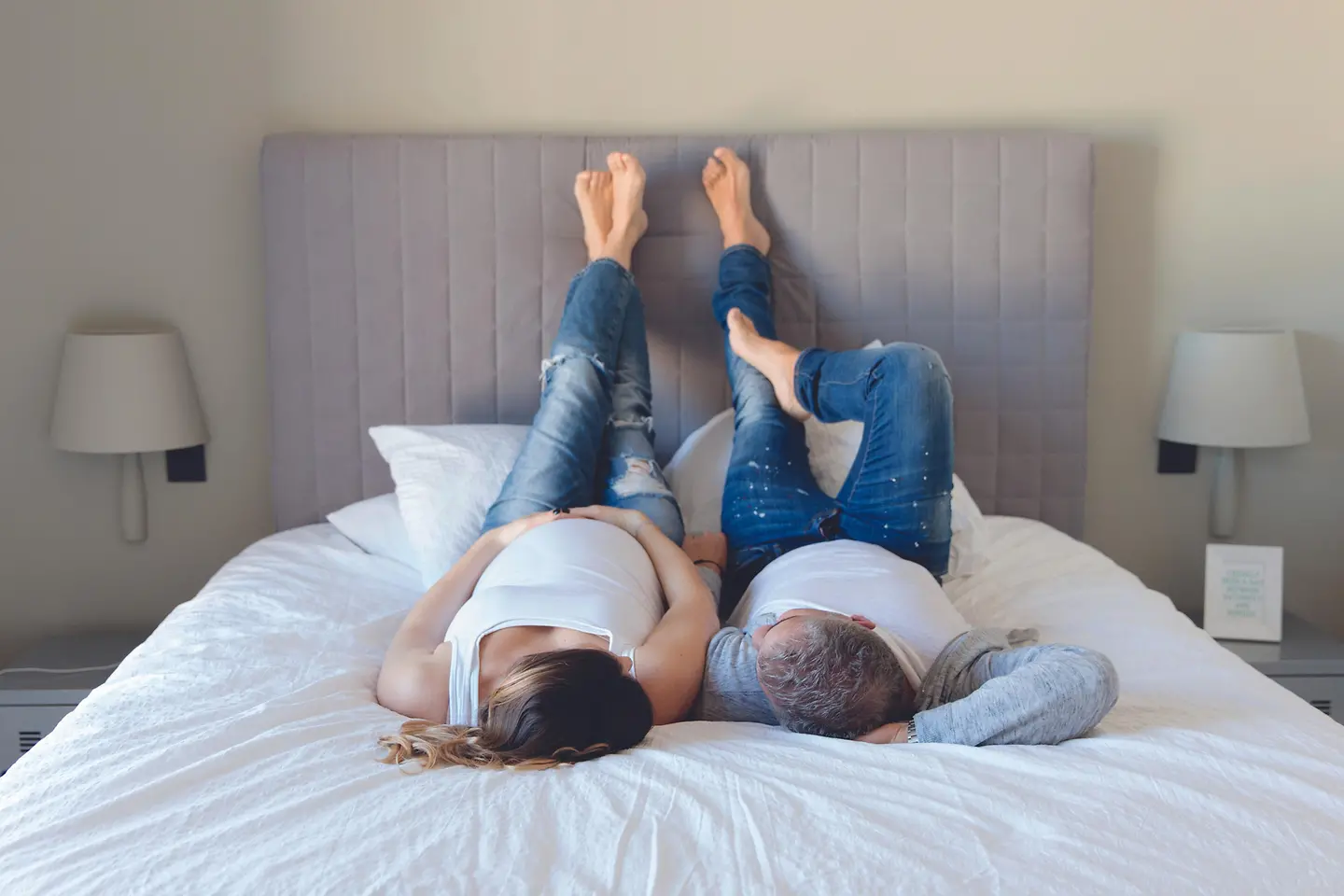 Eine schwangere Frau und ein Mann liegen auf einem Bett