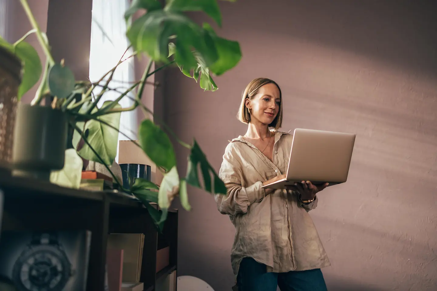 Frau mit Laptop am Fenster