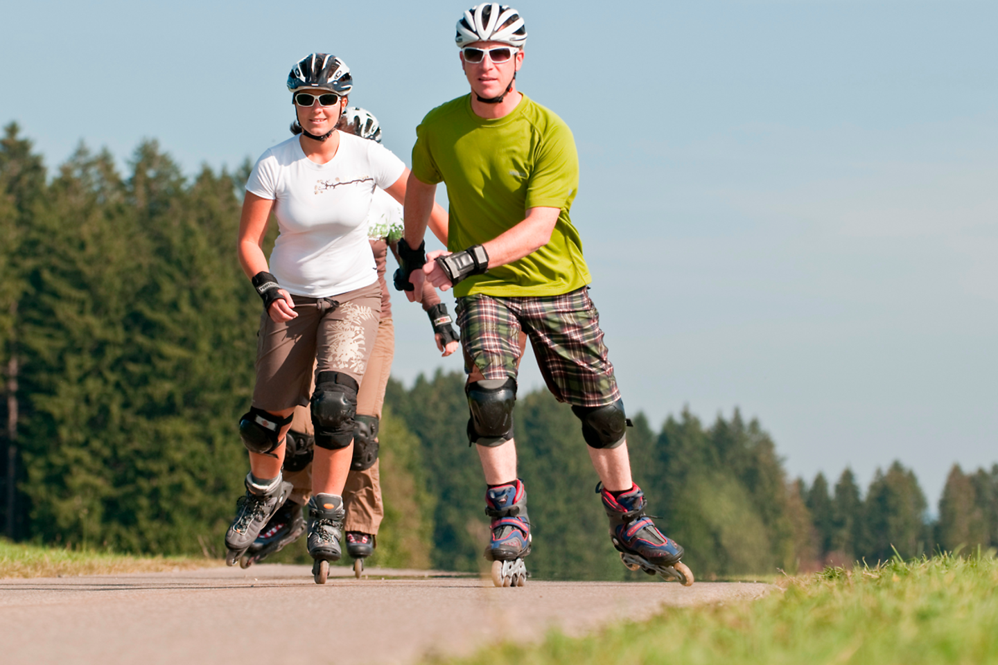 Zu sehen sind mehrere Inlineskater auf einem Asphaltweg