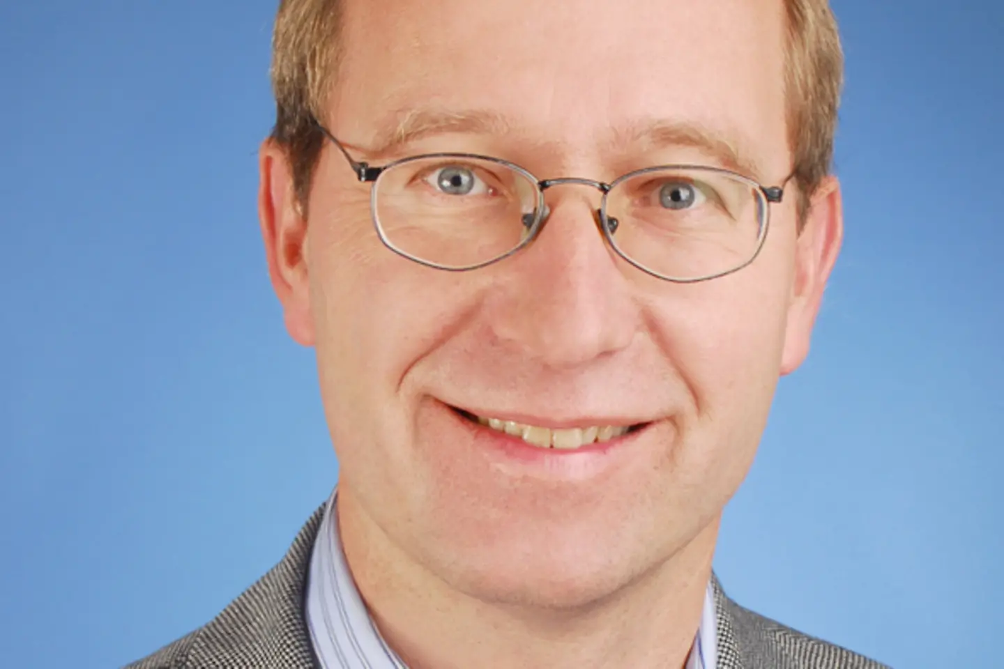 Ein Mann mit Brille lächelt in die Kamera